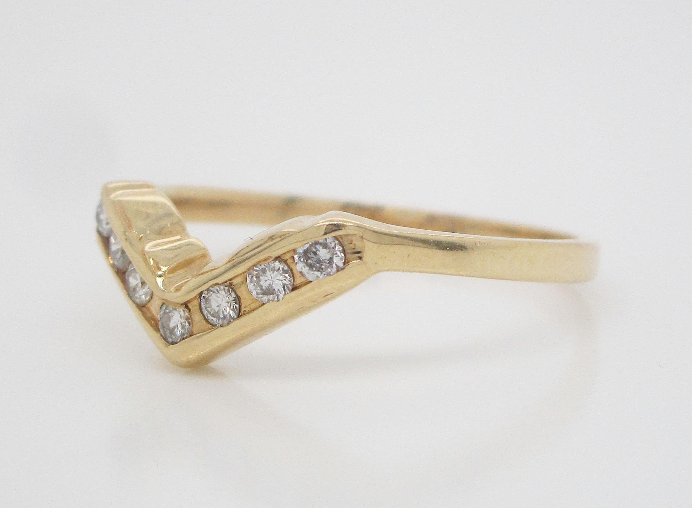 This beautiful estate ring is in 14k yellow gold and features an array of brilliant white diamonds settled into a dramatic angled layout. This band is ideal for stacking and would serve as a gorgeous wedding band if paired with an engagement ring