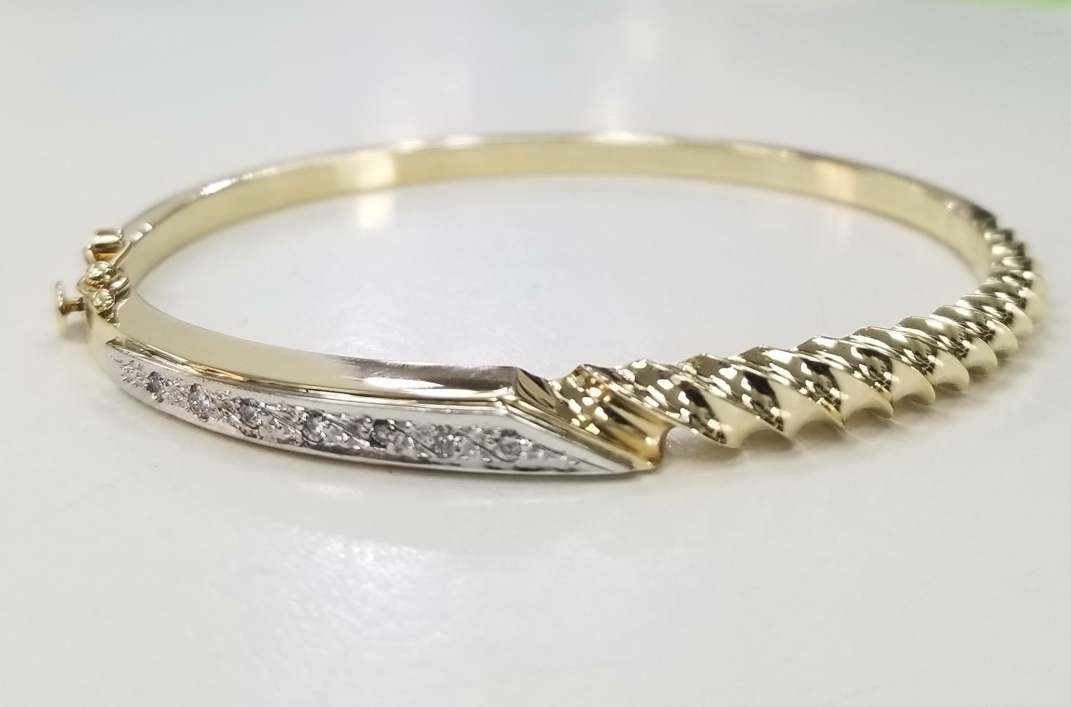 14k yellow gold diamond bangle with scallop design, containing 7 round full cut diamonds of very fine quality weighing .15pts.  Bracelet has plunger and safety. 