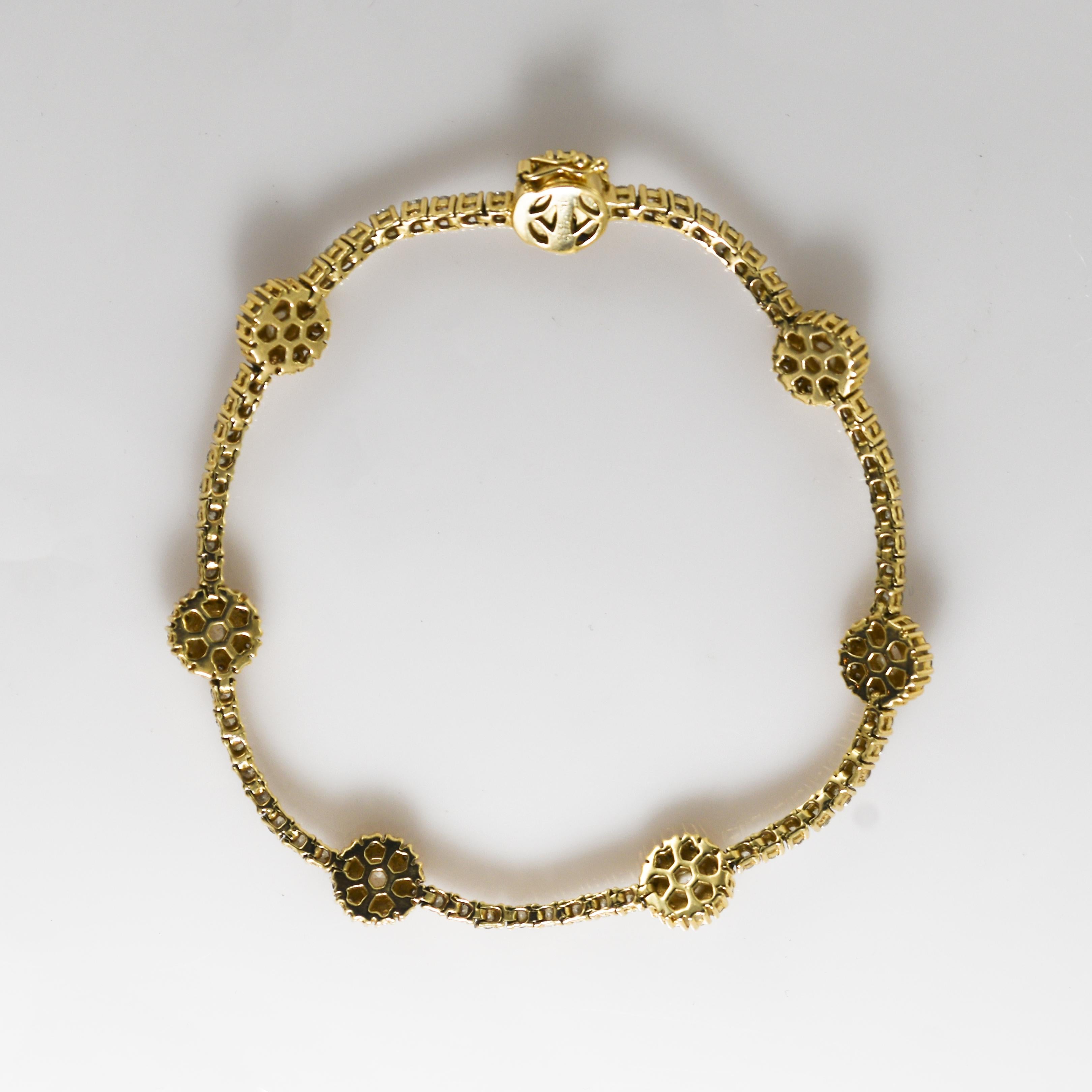 Bracelet pour dames en or jaune 14k et diamants.
Le dessous du fermoir est estampillé 14k, C.I.C., S 2.76.
Le poids total est de 16 grammes.
Les pierres centrales sont en forme de dôme avec des facettes fantaisie, d'environ 0,30 carat chacune, soit