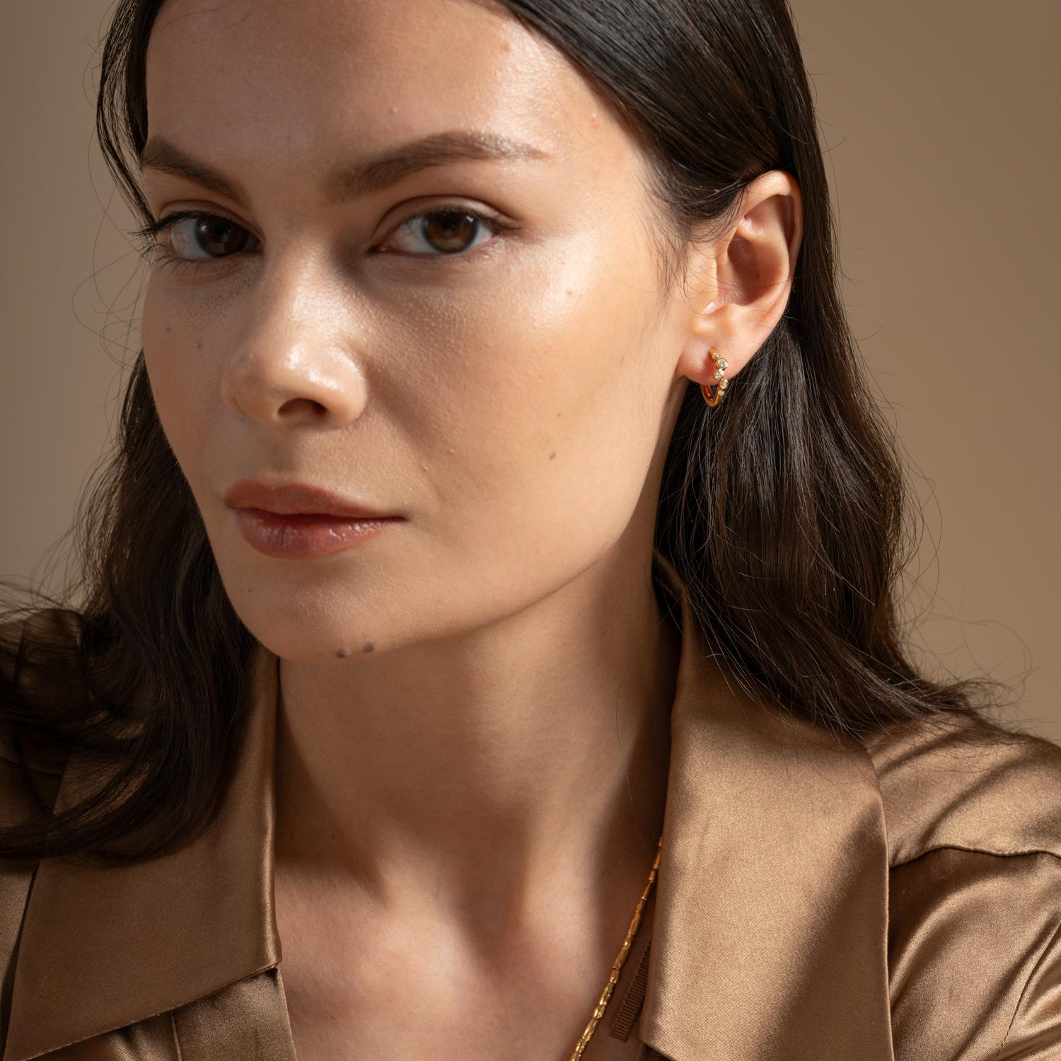 Love hoops? Upgrade any outfit with these diamond Cascade huggie hoops that are handcrafted in recycled 14k solid yellow gold. The hinged earrings are set with a cluster of sparkling white diamonds that are encased in fine rub-over settings. A