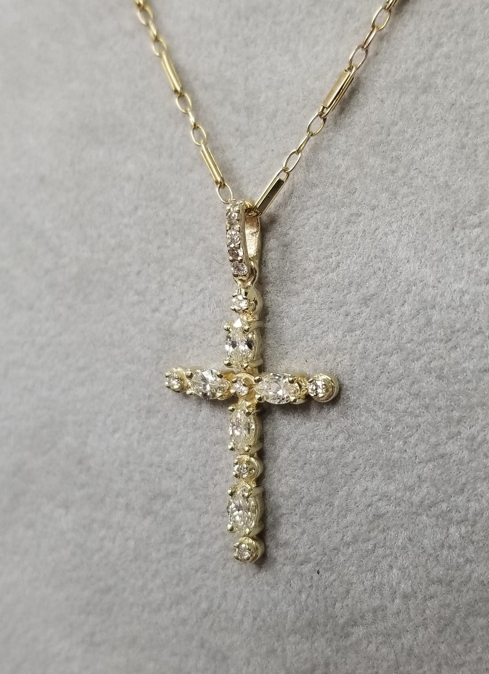 14k yellow gold diamond cross containing, 5 marquise cut diamonds and 11 round diamond weighing total weight of .86pts. on a 18 inches chain.