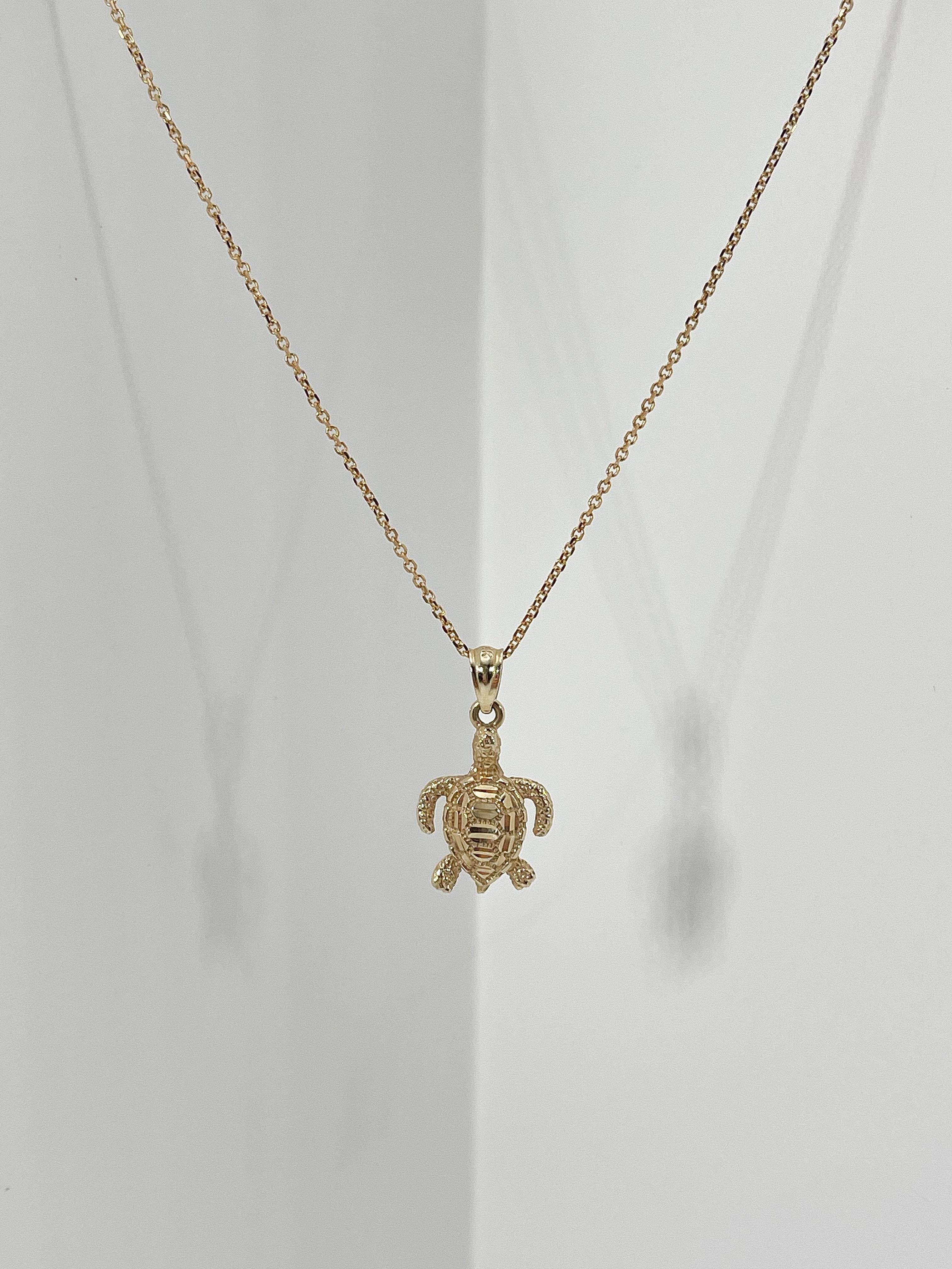 14k yellow gold diamond cut turtle pendant necklace. Pendant comes on an 18 inch diamond cut cable chain, has a lobster clasp to open and close, the turtle measures to be 15.5mm x 12mm, and has a total weight of 2.6 grams.