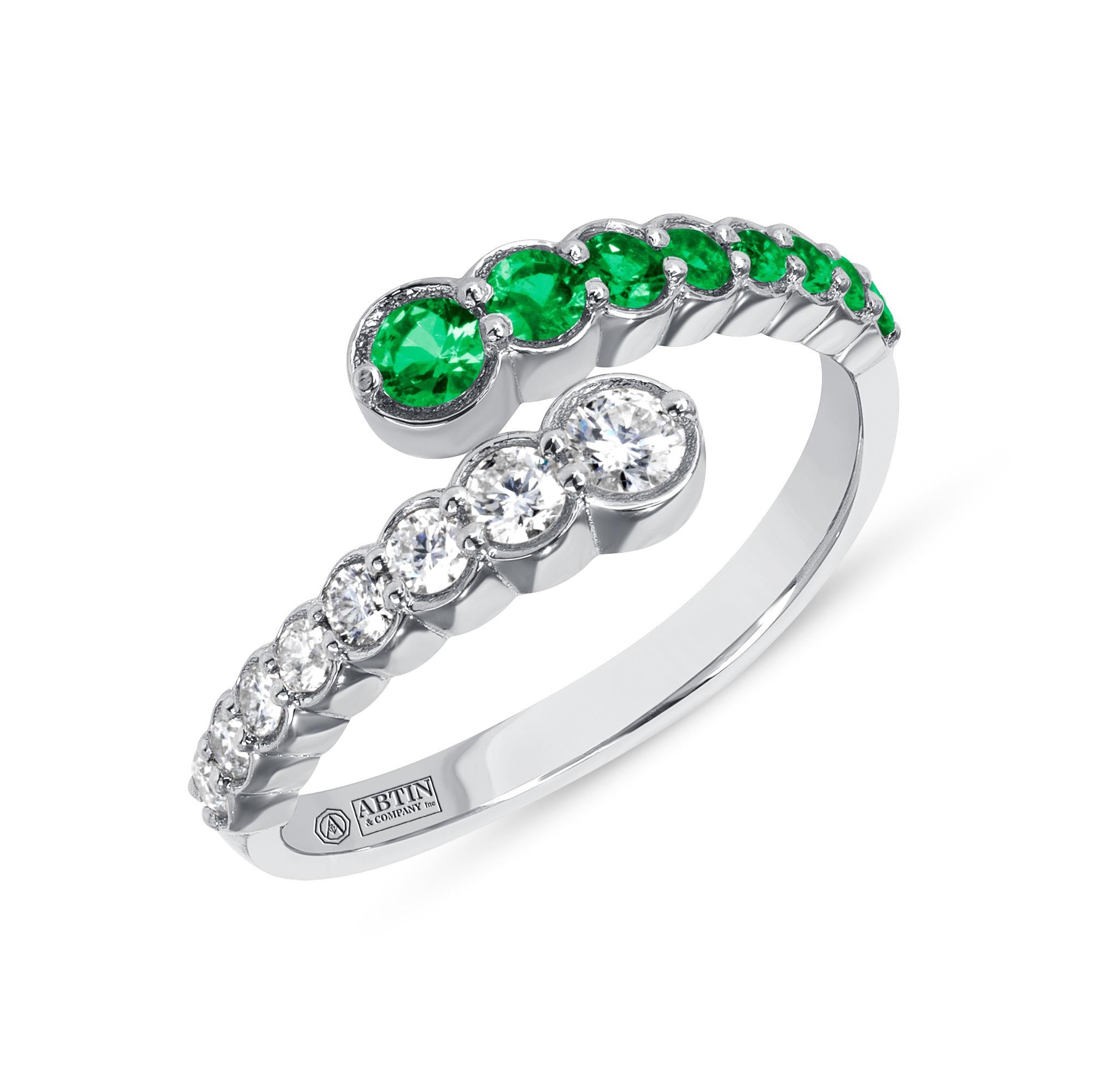 Crafted in 14K gold this ring features clean and contemporary lines. This modern and stylish open bypass ring is set with mesmerizing round-cut 
diamonds and genuine emeralds. Stack it with your stacking rings or wear it solo to elevate any