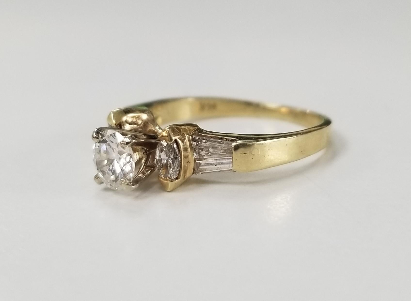 14k yellow gold diamond engagement ring, containing 1 brilliant cut diamond; color G, clarity VS and weight .35pts. and 2 marquise cut diamonds and 4 baguette cut diamonds of very fine quality weighing .25pts. ring is a size 4.5 and can be sized to