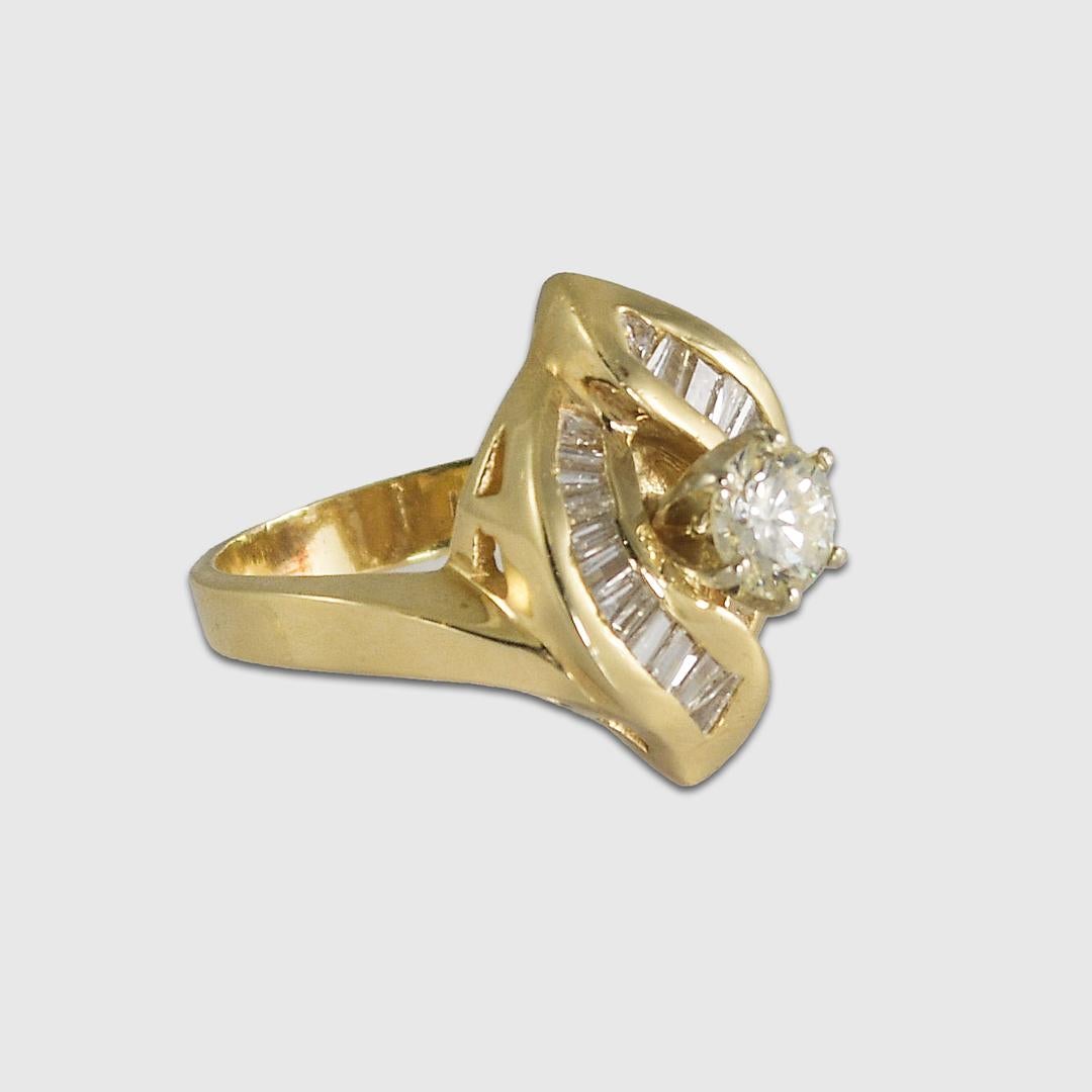 Bague de fiançailles en or jaune 14k et diamants.
Estampillé 14KP, il pèse 6,9 grammes.
Le diamant central est un diamant rond de taille brillant, .50 carats, couleur J à K, pureté Si, bonne taille.
Les diamants latéraux sont des diamants baguettes,