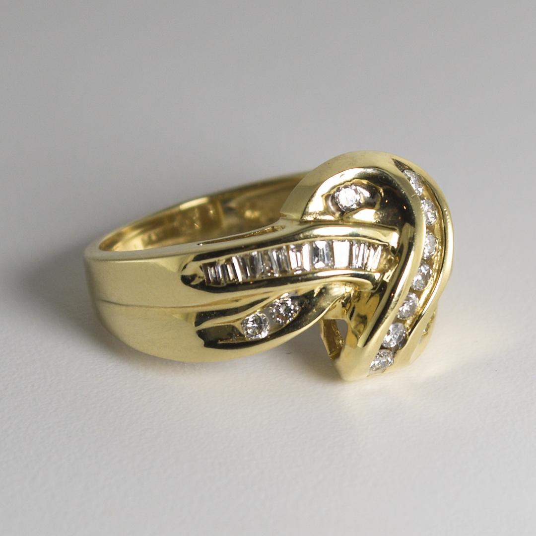 Questo anello in stile viaggio in oro giallo 14 carati pesa 5,10 grammi.
Contiene quattordici diamanti tondi brillanti, per un peso totale di 0,30 carati.
L'anello ha anche diciassette diamanti a forma di baguette, per un peso totale di 0,35