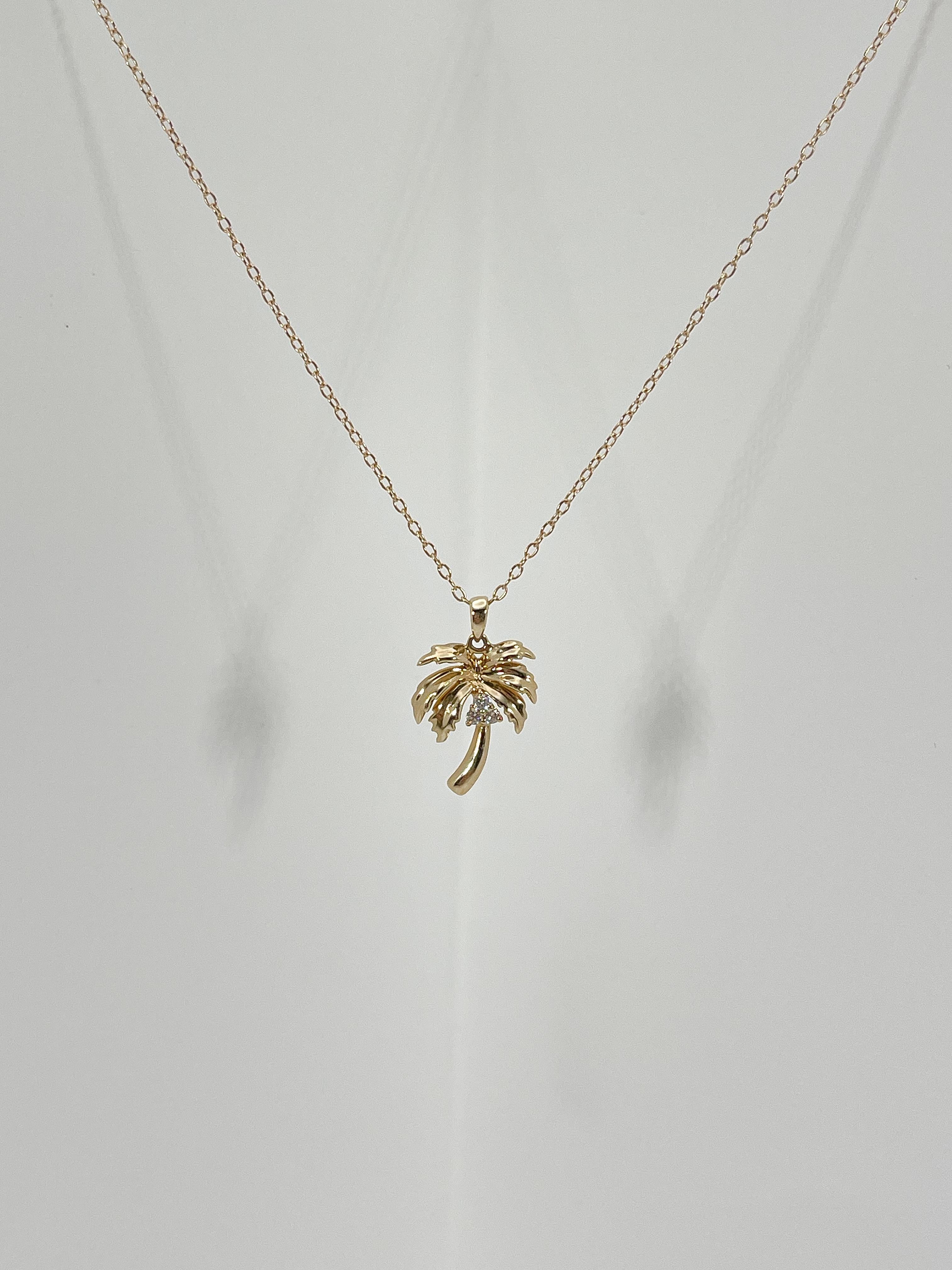 14k yellow gold diamond palm tree pendant necklace. There are 3 diamonds in the center of the pendant and they are all round, the pendant comes on a 16 inch diamond cut cable chain with an extension to 17 inches, has a spring ring to open and close,
