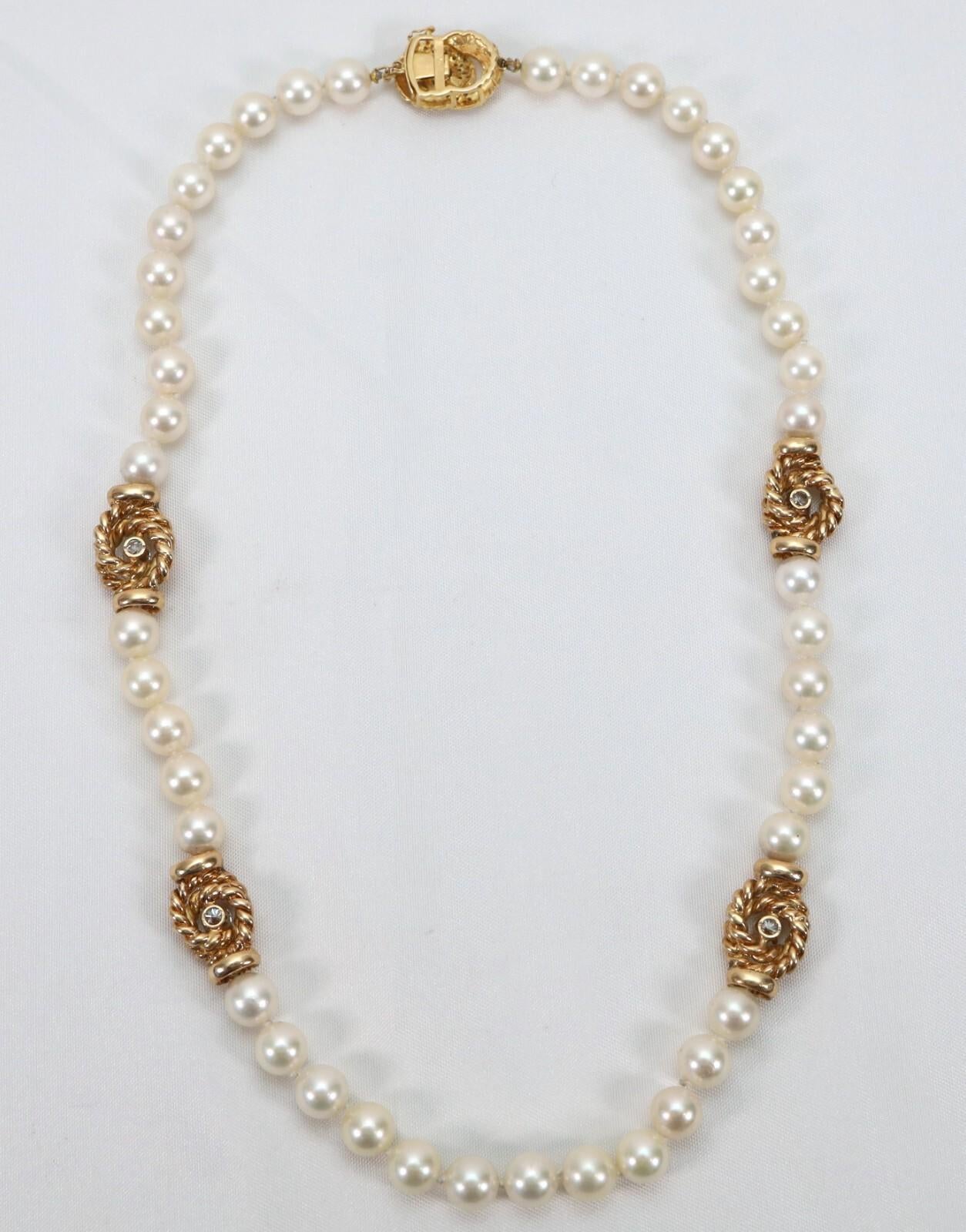 Este elegante collar de oro de 14k mide aproximadamente 21 pulgadas y exhibe un clásico collar de lustrosas perlas cultivadas redondas. Intercaladas a lo largo de la cadena hay cuatro estaciones de oro ornamentadas, cada una con un diseño de cuerda