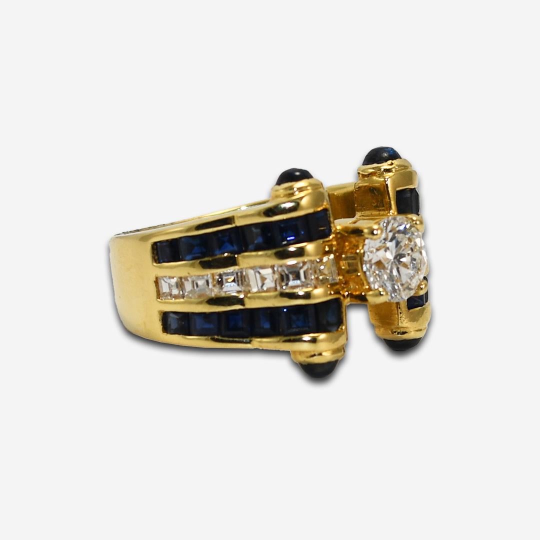 Diamond and blue sapphire ring in 18k yellow gold.
Stamped 18k, 750, and weighs 9.5 grams gross weight.
The center diamond is a round brilliant cut, .65 carats, G, H, I color, i1 clarity, good cut.
On the sides are 1.00 total carats of natural blue