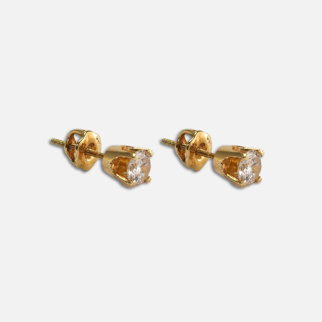 This is a pair of 14k yellow gold diamond stud earrings.
These earrings contain two 4.25mm round brilliant diamonds at 0.56ct weight. 
Color is K to L, SI to i1 clarity mounted in 4 prong settings with screw back fastening.
These earrings are