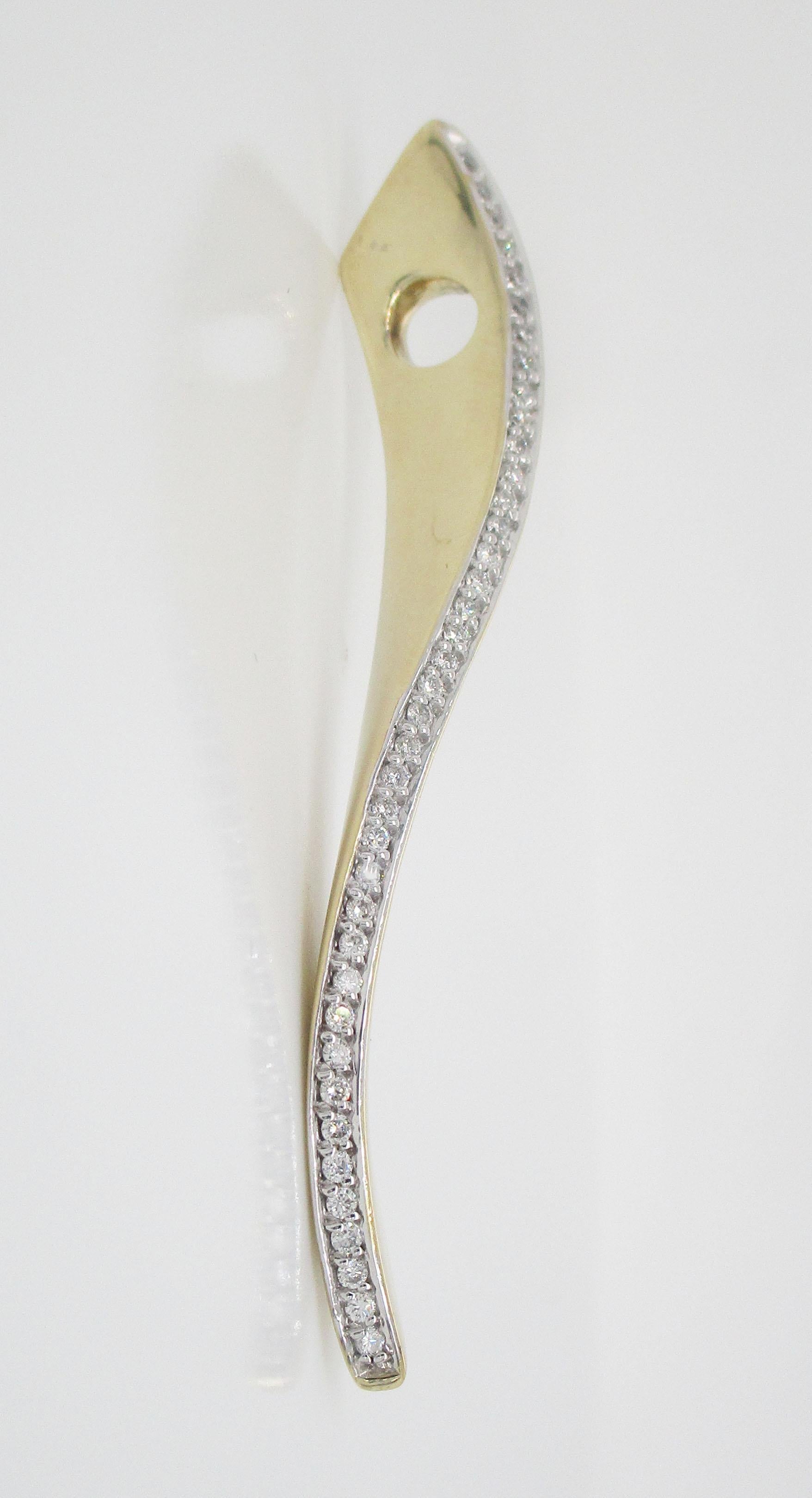 This is a beautiful pendant in 14k yellow gold with a stunning array of brilliant white diamonds! The unique design of the pendant features a wave design accented by a soft twist that makes this pendant both visually interesting and impossible to