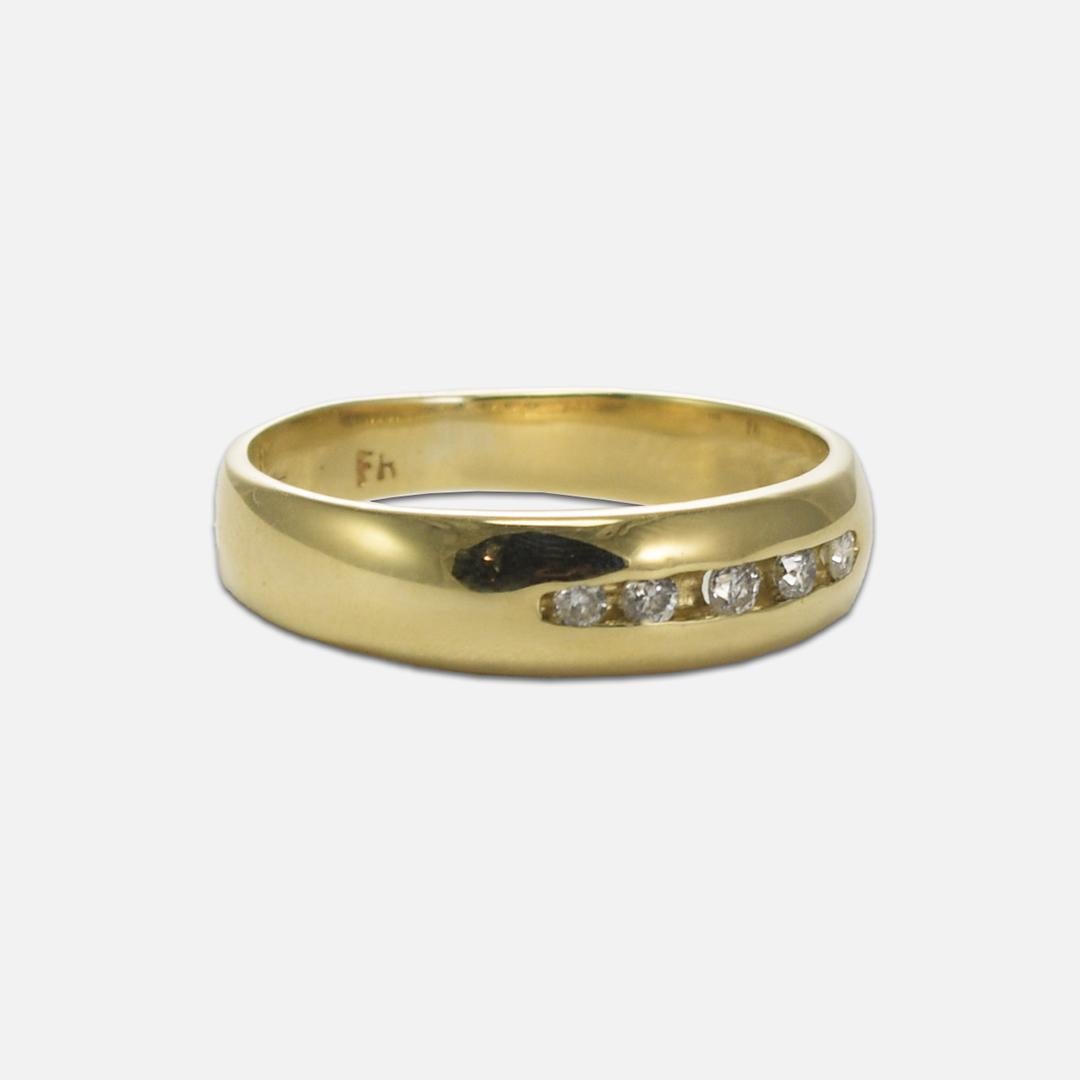 Men's 14k yellow gold and diamond wedding band.
Stamped 14k and weighs 3.6 grams.
Test 57.5% gold with an XRF analyzer.
There are five round brilliant cut diamonds, .10 total carats, H to I color, i1 clarity, and good cuts.
The ring measures 5mm
