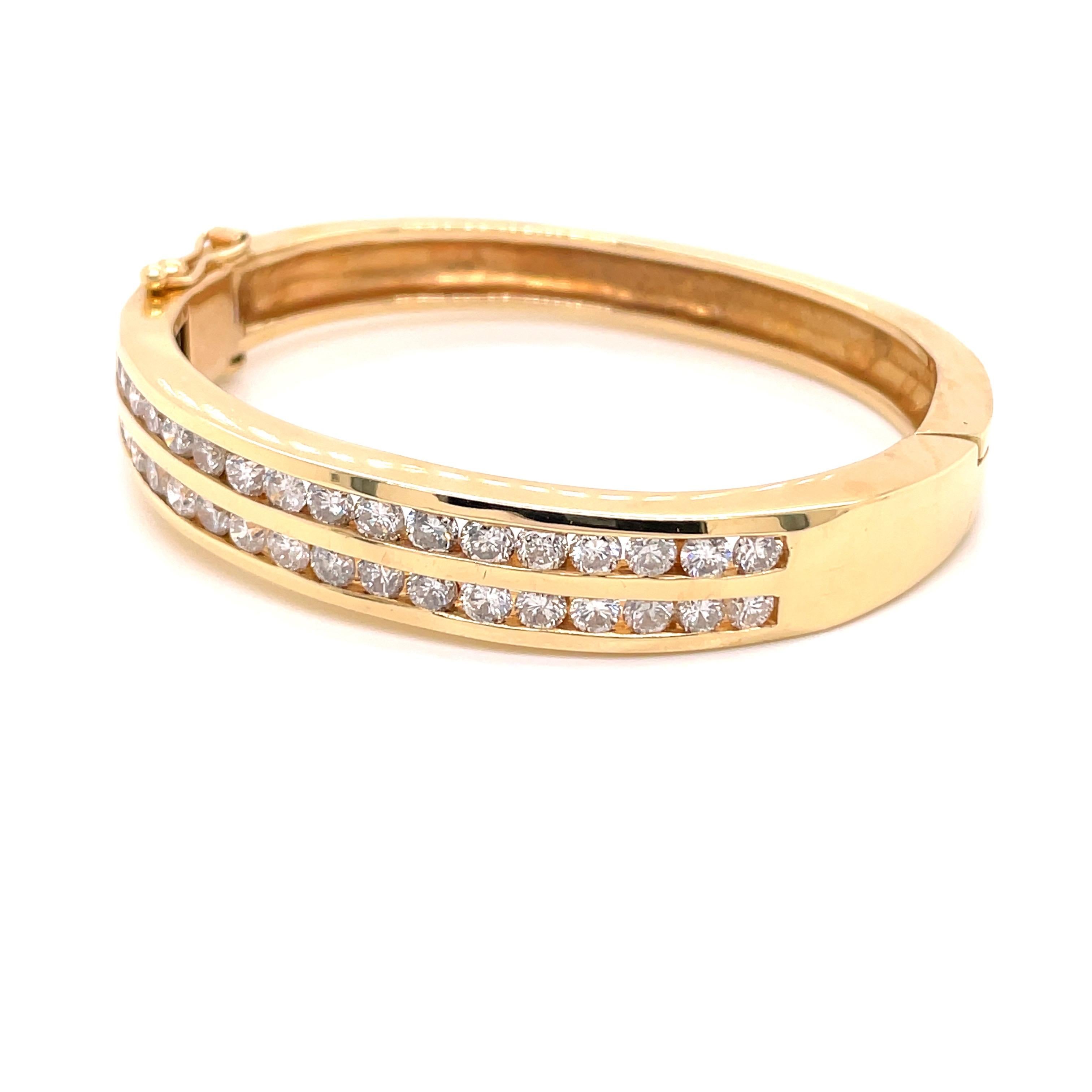 14K Yellow Gold Double Wide Channel Diamond Bangle Bracelet 4.25ct - The bangle is set with 34 round brilliant diamonds weighing 4.25ct with G-I color and I1 clarity. The width of the bangle is 9.7mm on top and tapers to 7.2mm on the bottom. The