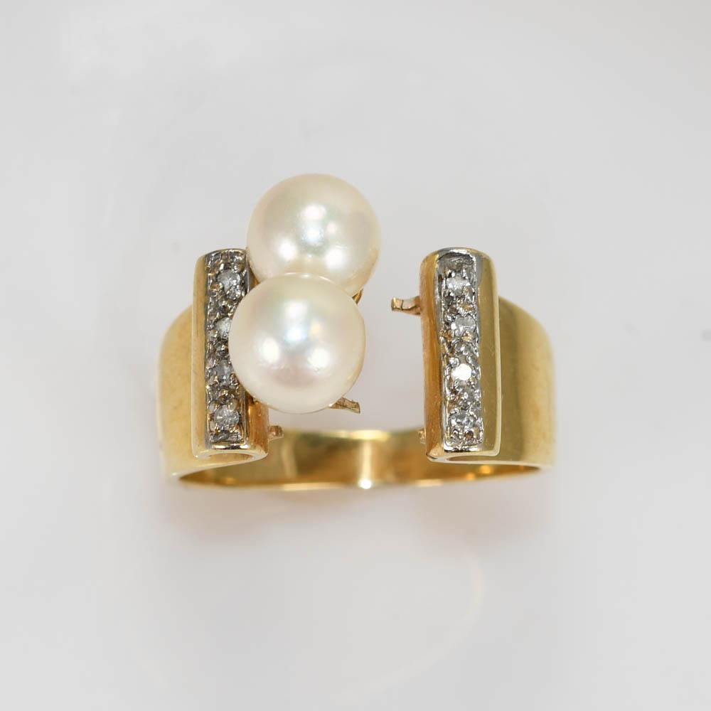 14k yellow gold ring.
Set with two pearls 6.5mm each and 8 diamonds .01ct each.
weighs 6.3g stamped 14k
size 6.25