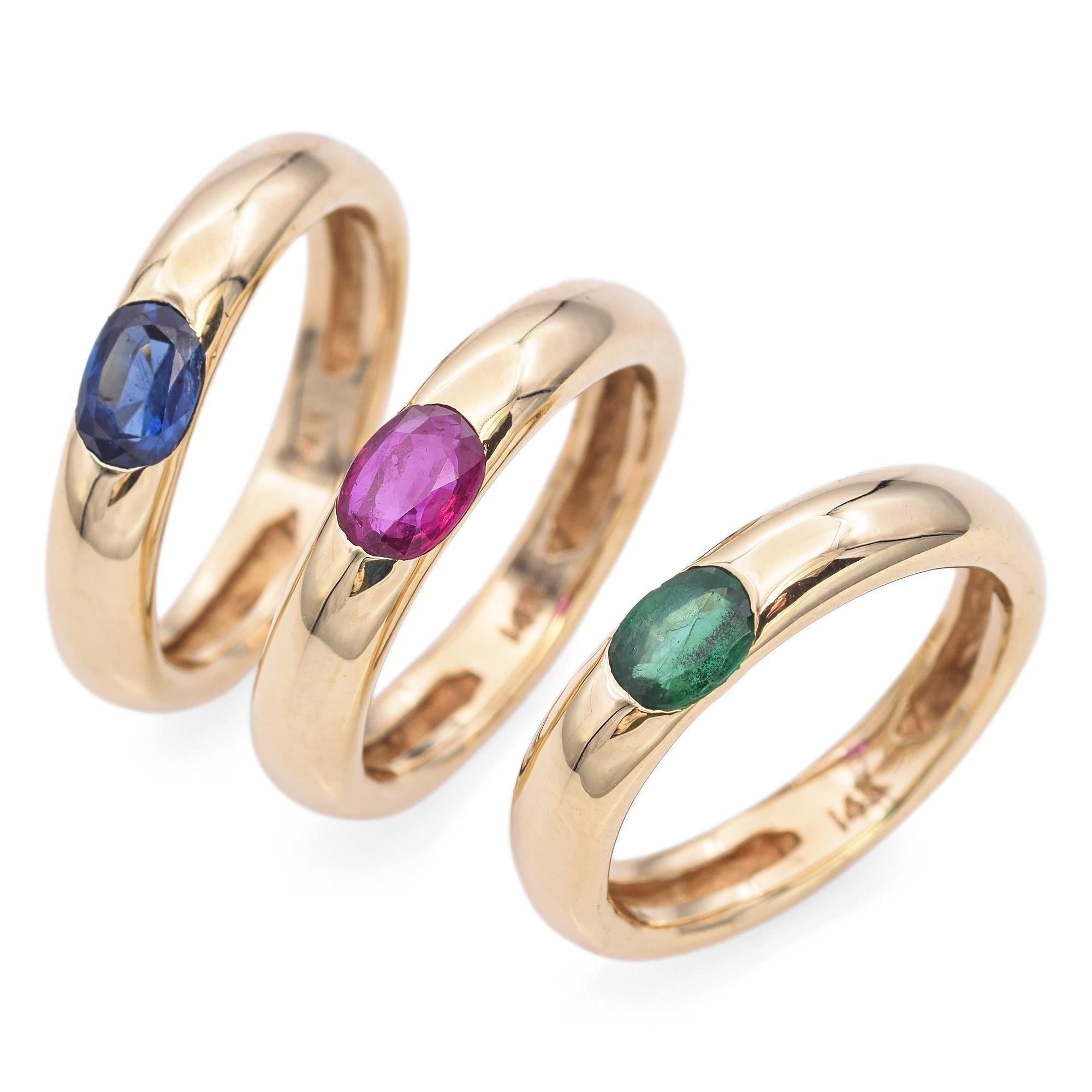 Contemporary Yellow Gold Stackable Rings. These elegant stackable rings are crafted in 14k yellow gold. The top ring features a stunning oval-cut blue sapphire, while the middle ring showcases a vibrant oval-cut red ruby. The bottom ring is adorned