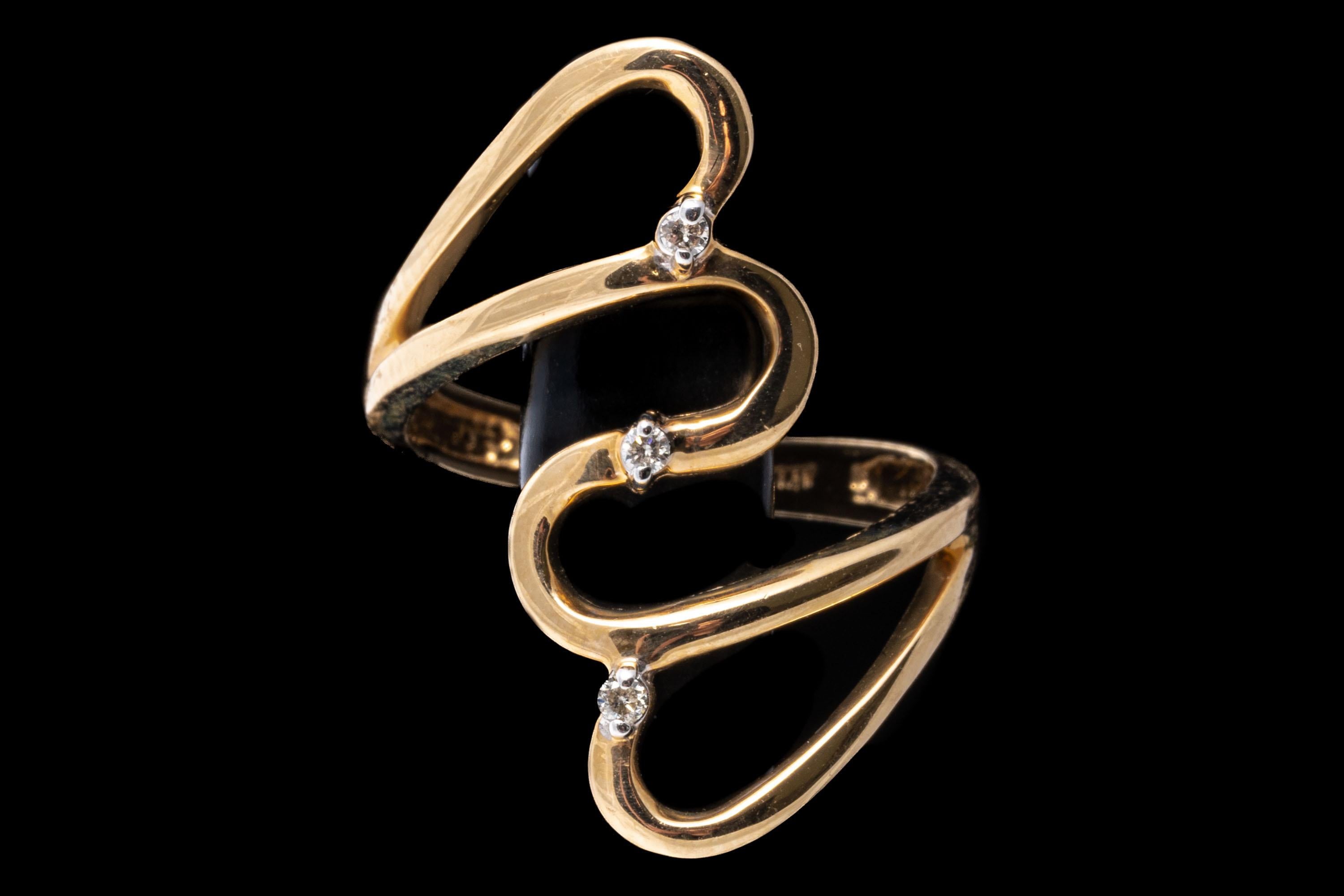 14k yellow gold ring. This yellow gold, elongated bypass style ring is high polished finished, punctuated by opposing open hearts and finished with round faceted, accent diamonds, approximately 0.03 TCW, prong set.
Marks: 14k
Dimensions: 1/2