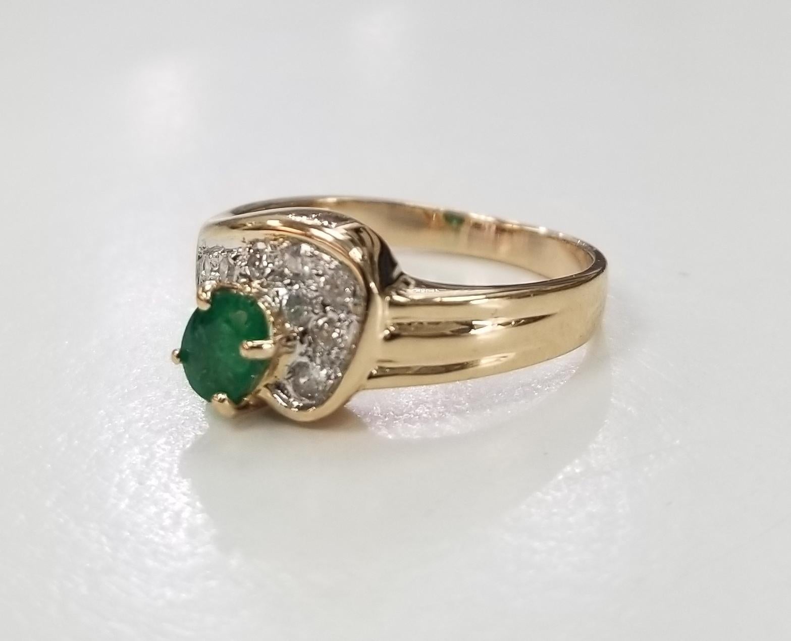 14k yellow gold emerald and diamond ring, containing 1 emerald weighing .25pts. and 8 round full cut diamonds of very fine quality weighing .16pts. ring size is 5 and can be sized to fit for free.