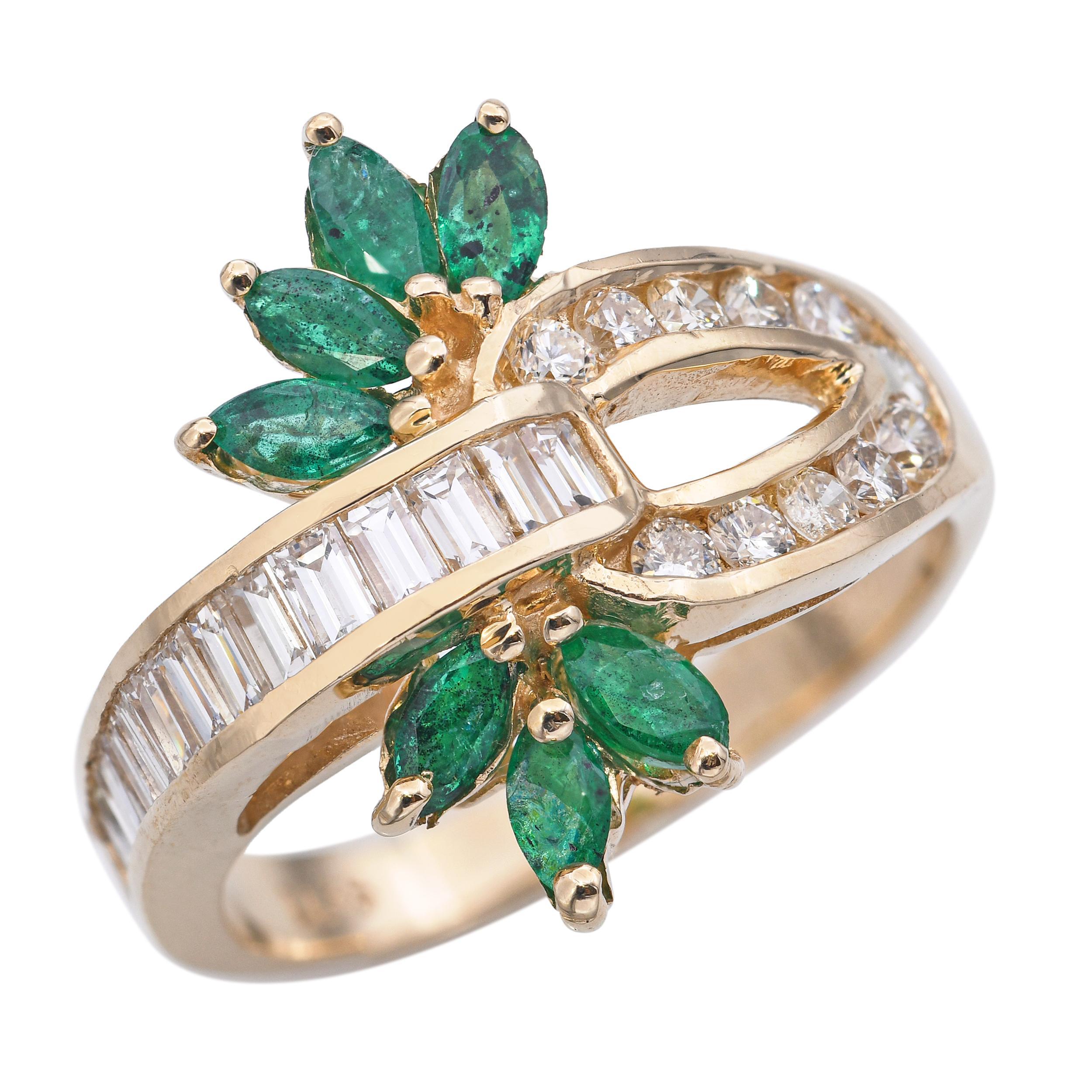 Cette bague en or jaune 14k présente un délicat motif floral avec des émeraudes vibrantes et des diamants étincelants entrelacés dans un design élégant. Les riches émeraudes vertes forment les pétales, tandis que les diamants taille brillant
