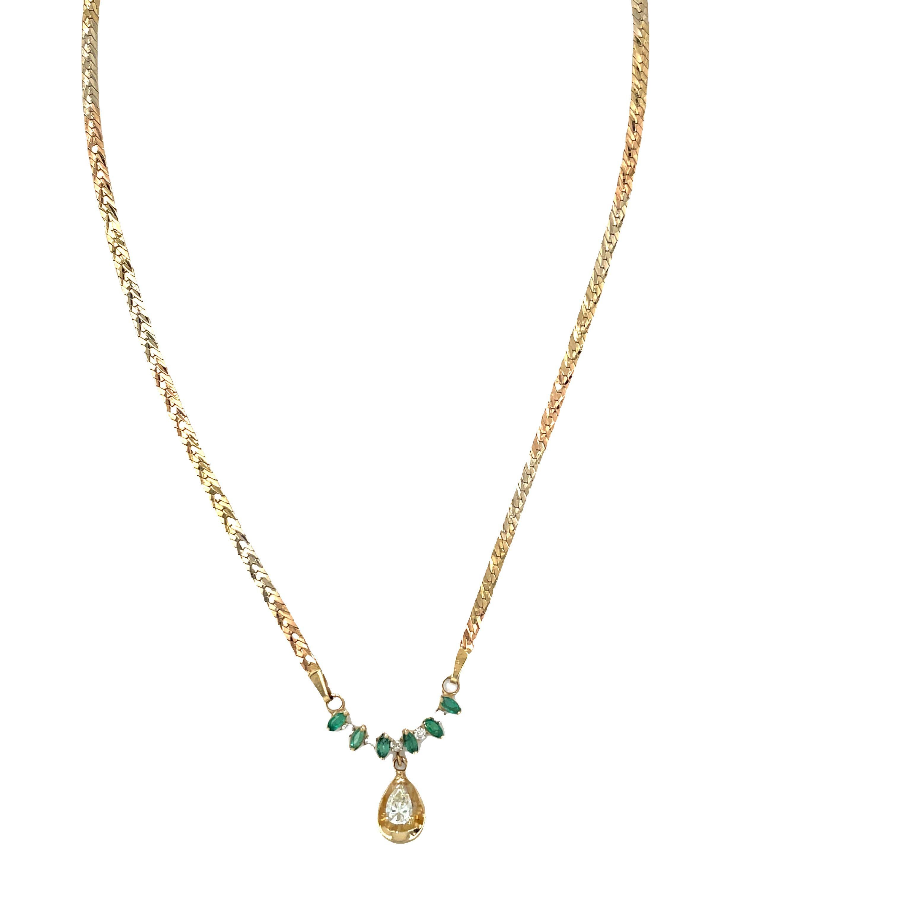Questa bellissima collana combina elementi di ispirazione vintage con un tocco di eleganza. È caratterizzato da un diamante a forma di pera, circondato da una placca d'oro e da uno smeraldo verde vibrante, che crea uno splendido pendente a goccia.
