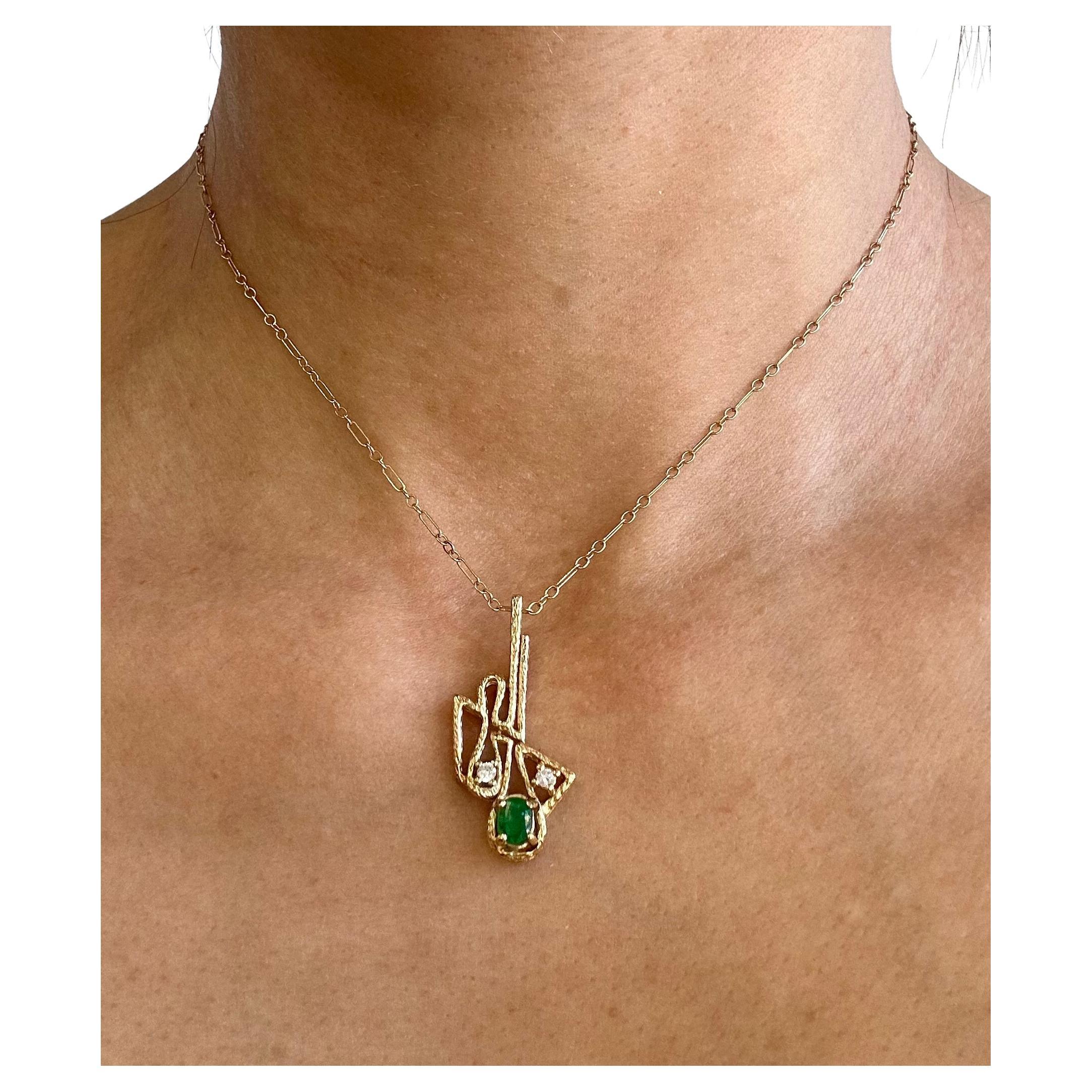 Ce magnifique collier pendentif en or jaune 14K à émeraudes et diamants, d'occasion et renouvelé, respire l'élégance classique. Le pendentif, qui mesure 19 mm de largeur et 35 mm de longueur, est orné d'une vibrante émeraude de 5,35 x 4 mm, encadrée