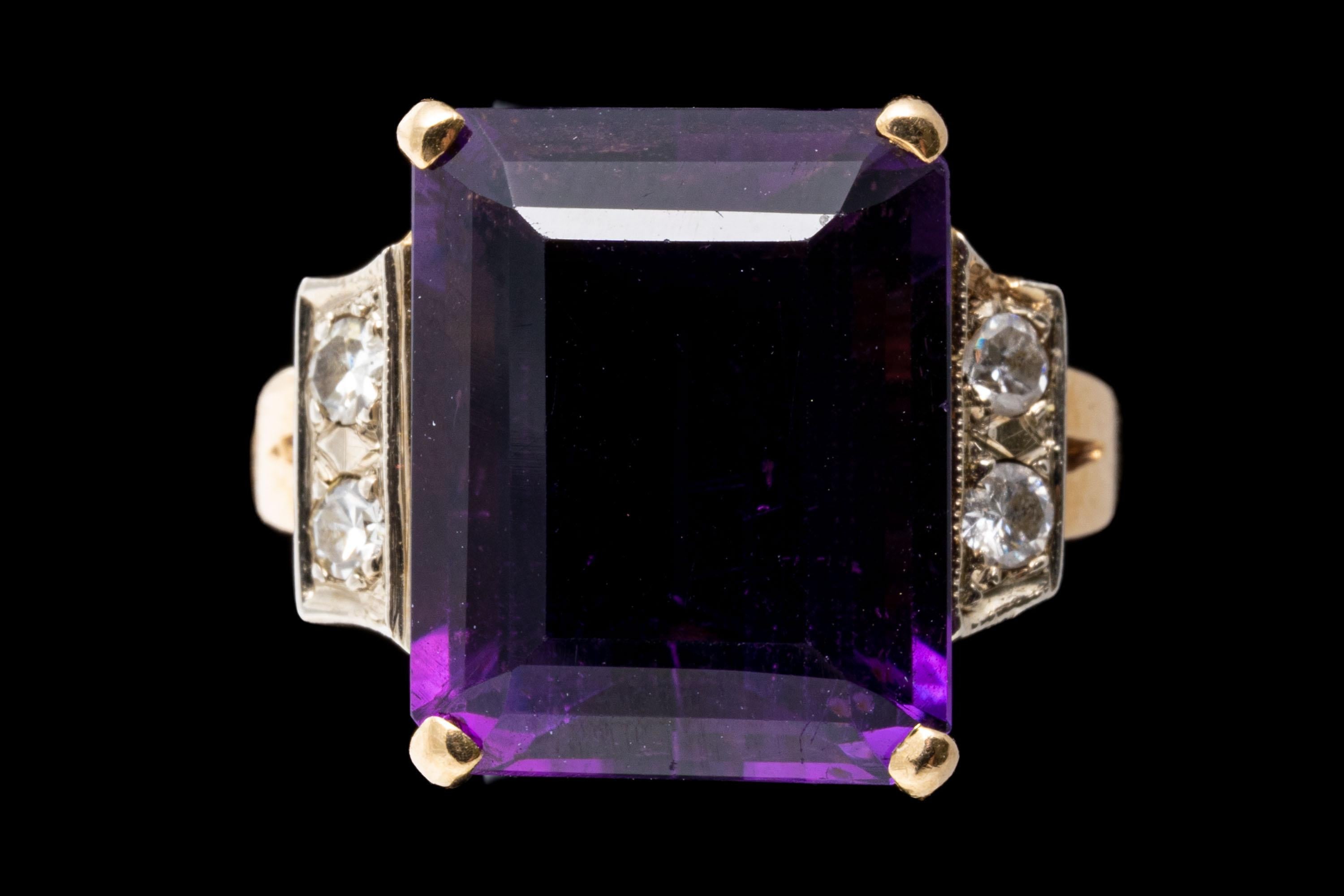 14k yellow gold ring. This gorgeous ring has a large emerald cut faceted, dark purple color amethyst center, approximately 9.25 CTS, prong set and flanked by two large single cut diamonds, approximately 0.12 TCW, and finished by split style