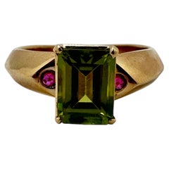 Anillo de oro amarillo de 14 quilates con peridoto talla esmeralda y acento de rubí, 3,50 ct de peso total