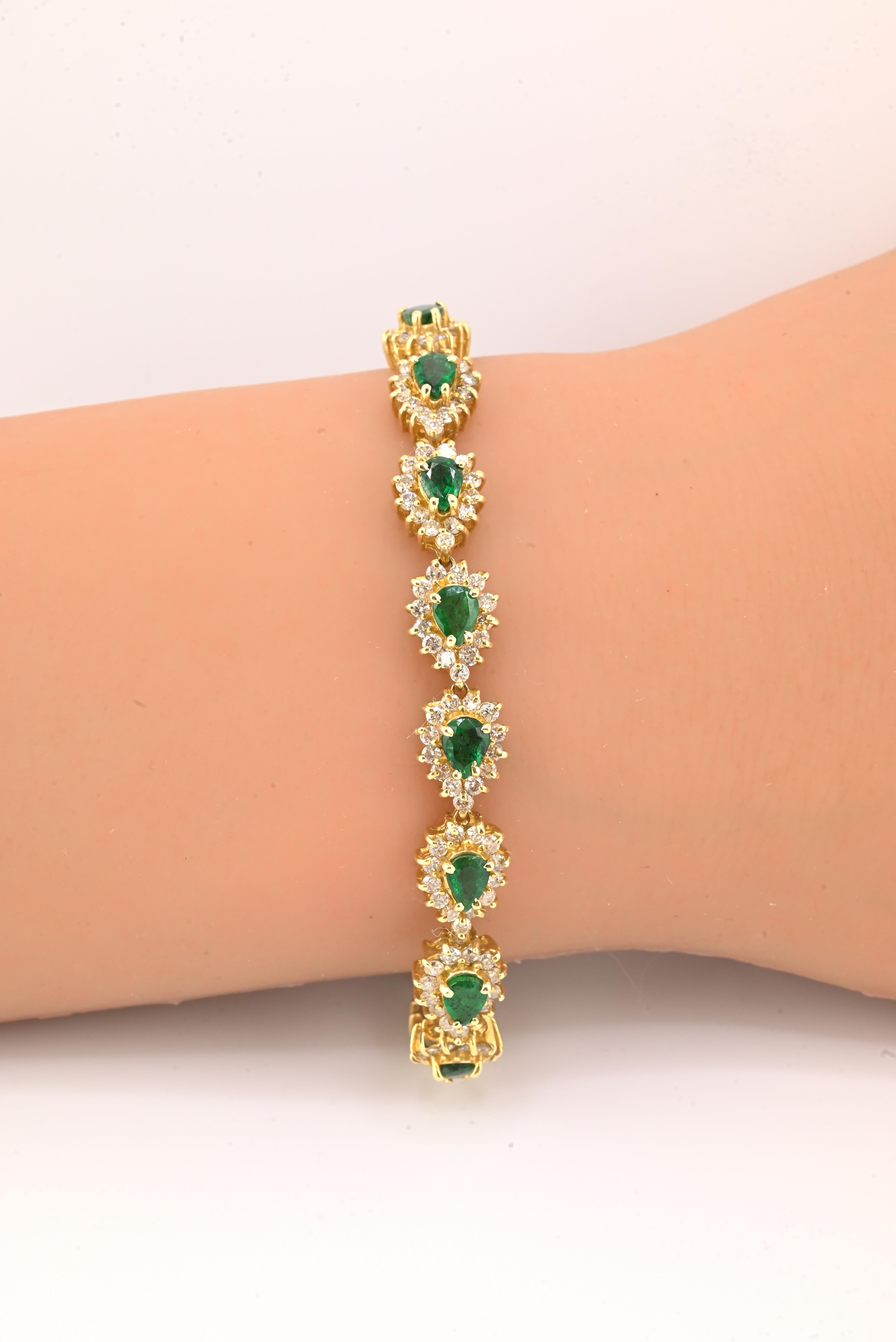 Magnifique bracelet en or jaune 14 carats orné d'émeraudes et de diamants. Les émeraudes naturelles vertes taillées en poire sont entourées d'un halo de diamants naturels étincelants. Un design luxueux et classique avec une présence exceptionnelle