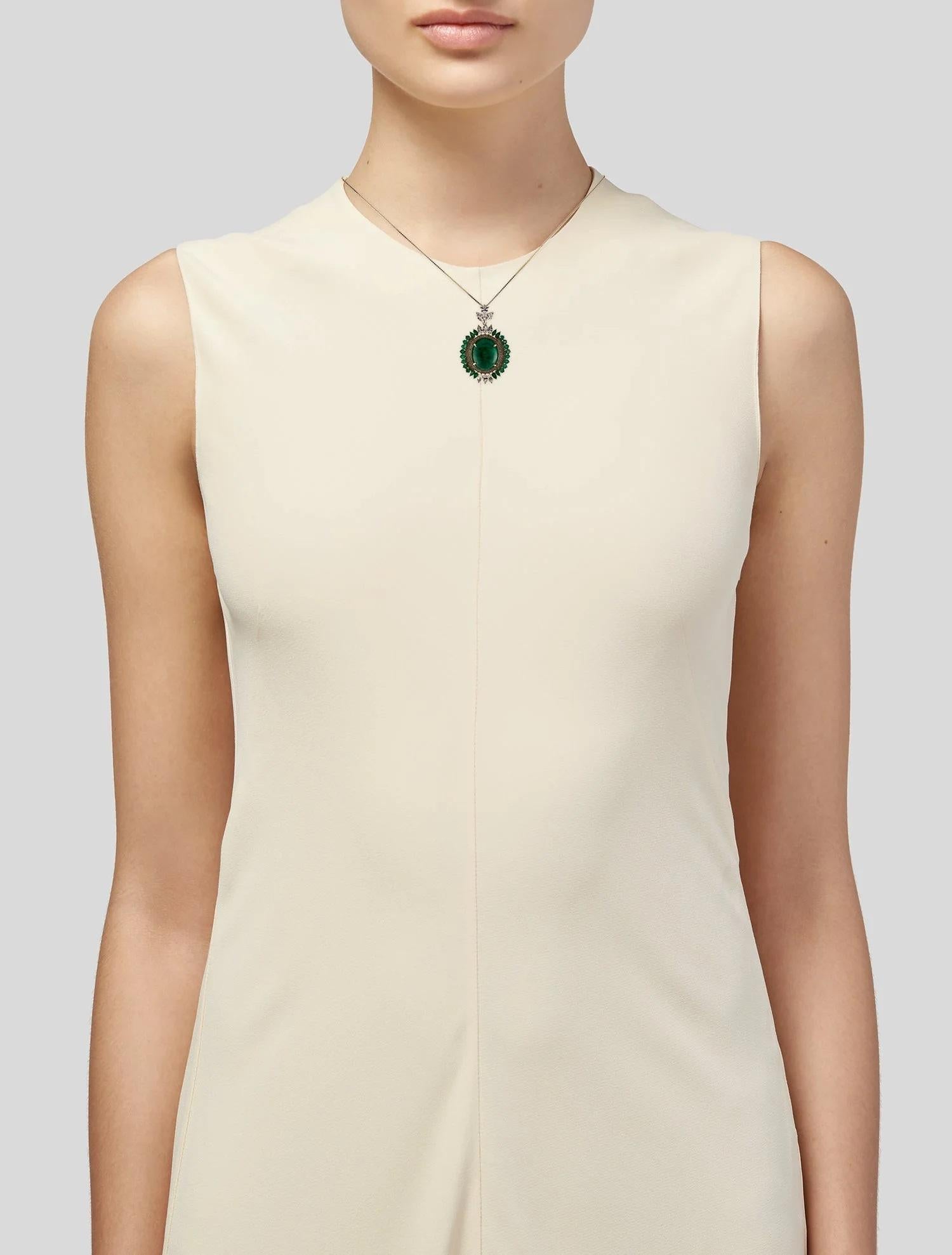 This striking 14K yellow gold pendant necklace highlights a captivating 19.35-carat oval cabochon emerald as the centerpiece, surrounded by an exquisite arrangement of sparkling diamonds and colorless sapphires. The pendant combines elegance and