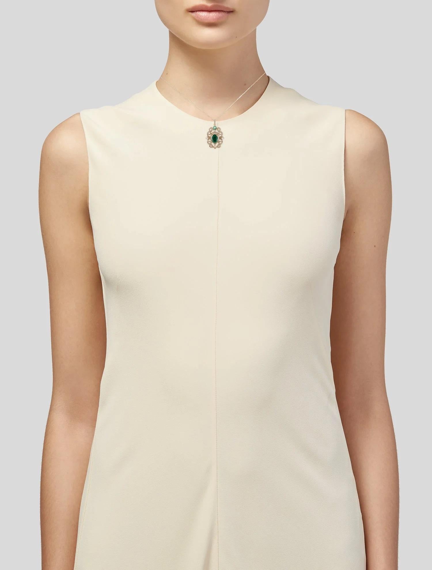 This exquisite 14K yellow gold pendant necklace showcases a harmonious blend of emerald, sapphire, and diamond accents, offering timeless elegance and sophistication. The pendant features a captivating oval cabochon emerald at its center, weighing