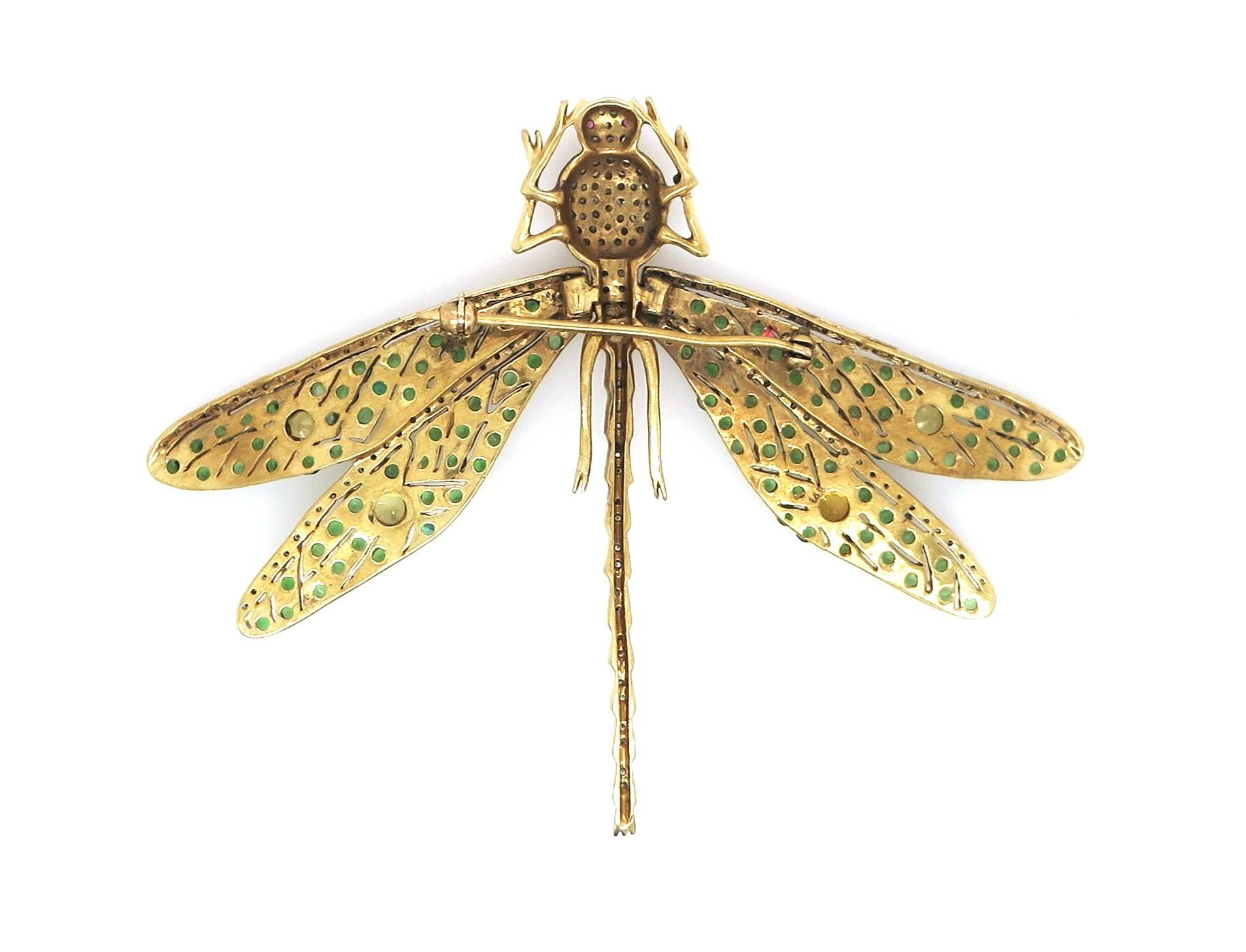 Featuring a 14 karat yellow gold vintage style dragonfly pin set with 107 natural Emeralds and 65 Round Brilliant Diamonds, 4 Citrines around the wings with 2 ruby eyes.
Estimated weight of the Emeralds – 2.14 carats
Estimated weight of the Diamonds
