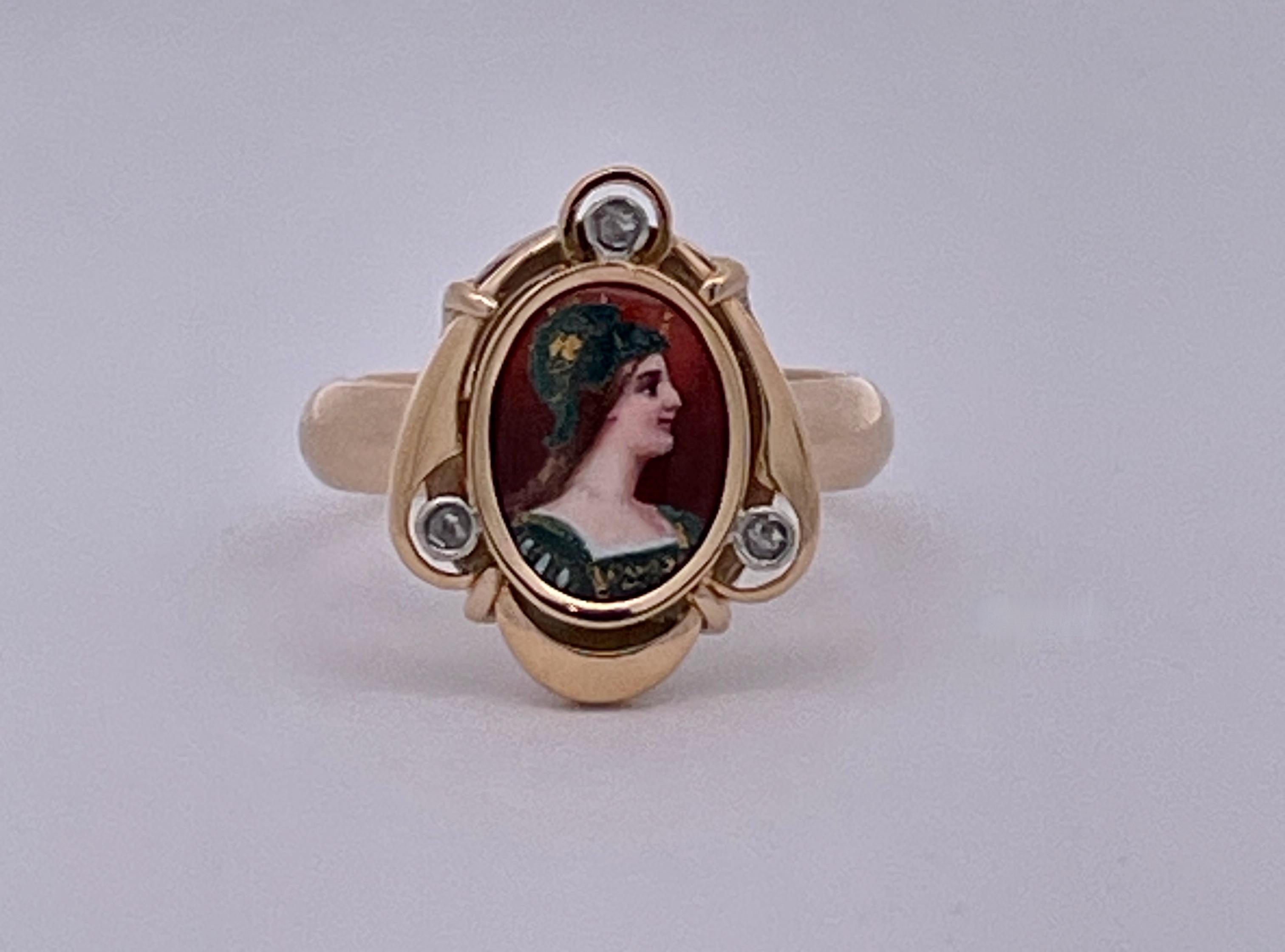 Cette jolie bague est ornée d'un portrait d'Athéna en émail et de trois minuscules diamants dans l'entourage. Il s'agit de  une petite bague parfaite pour les femmes aux mains plus petites ou comme anneau de petit doigt.  Il s'agissait au départ