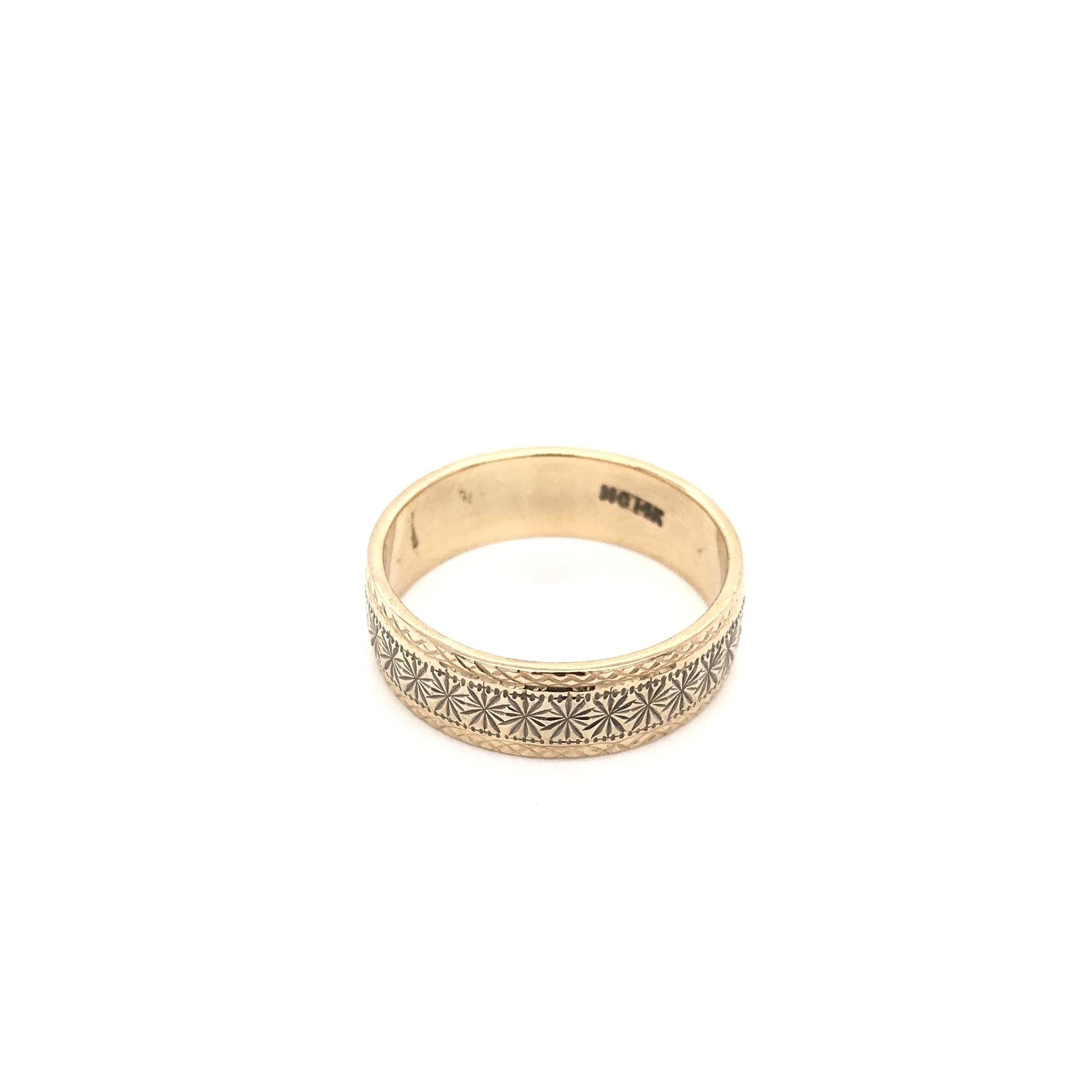This decorative gold band is an estate piece. This ring is 14k gold and features intricate starburst engravings encompassing the entire length of the band. The band also features fine milgrain accents and textured borders as well. The attention to