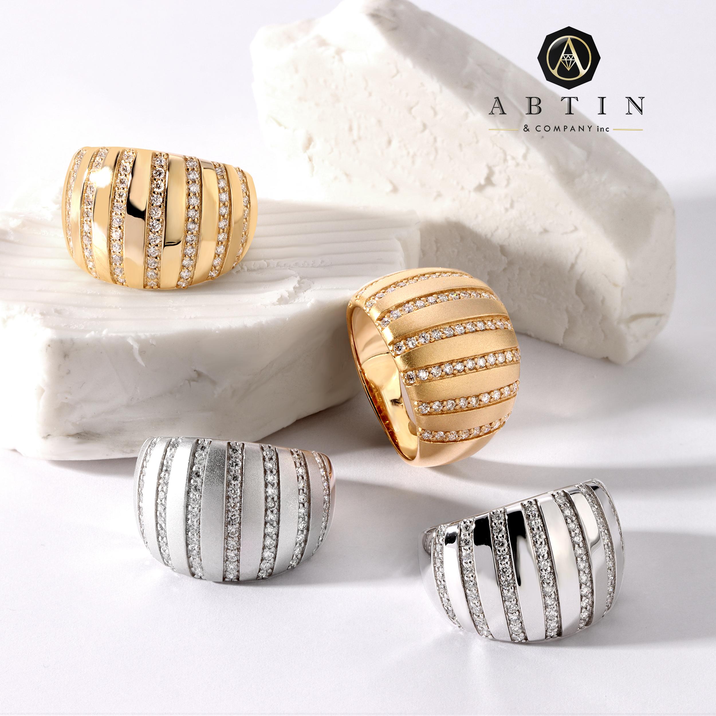 Dieser moderne Ring aus 14-karätigem Gold zeichnet sich durch gestreifte Diamanten aus, die die goldene Oberfläche sanft abrunden und durch perfekt gesetzte Reihen von Pave-Diamanten ergänzt werden. Die Details an diesem Ring sind kompliziert und