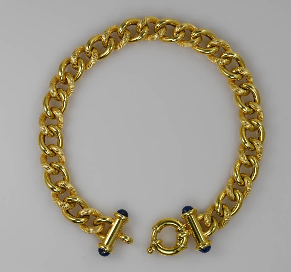 Bracelet à maillons fantaisie en or jaune 14k. 
Estampillé 14k Italie et pèse 10 grammes. 
Des pierres de lapis bleu se trouvent aux extrémités des barres du fermoir. 
Tous les autres maillons ont un design de surface texturé. 
Le bracelet mesure 8