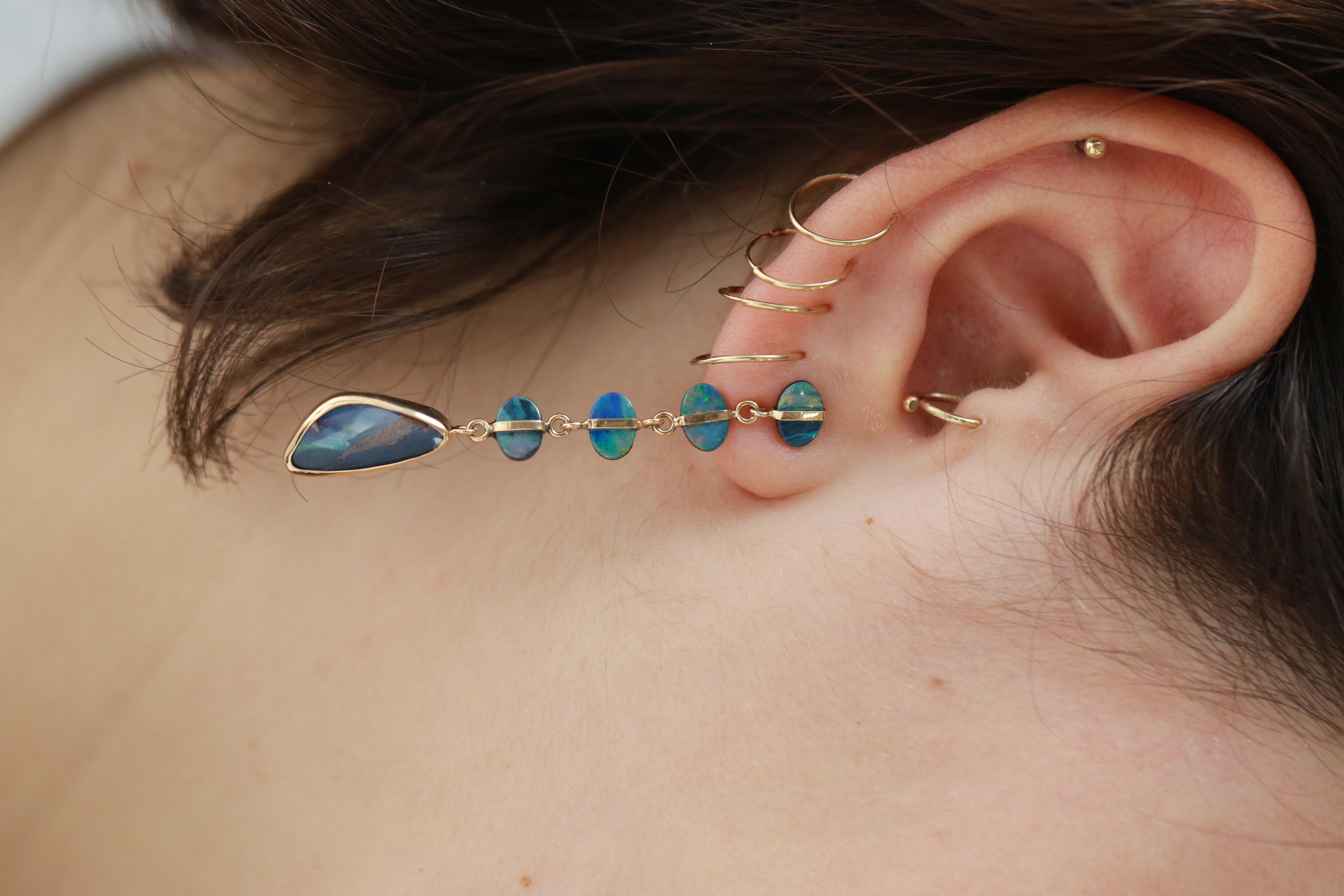 Ein harmonisches Set aus 4 ovalen Opalen ist elegant in 14-karätigem Gold eingefasst, darunter baumeln Opale in Tropfenform.

Steine:
4 Paar blaue ovale australische Opale, je 5x7mm
1 Paar Freiform-Dreiecke aus Boulder-Opal, 2,93ct, blau,