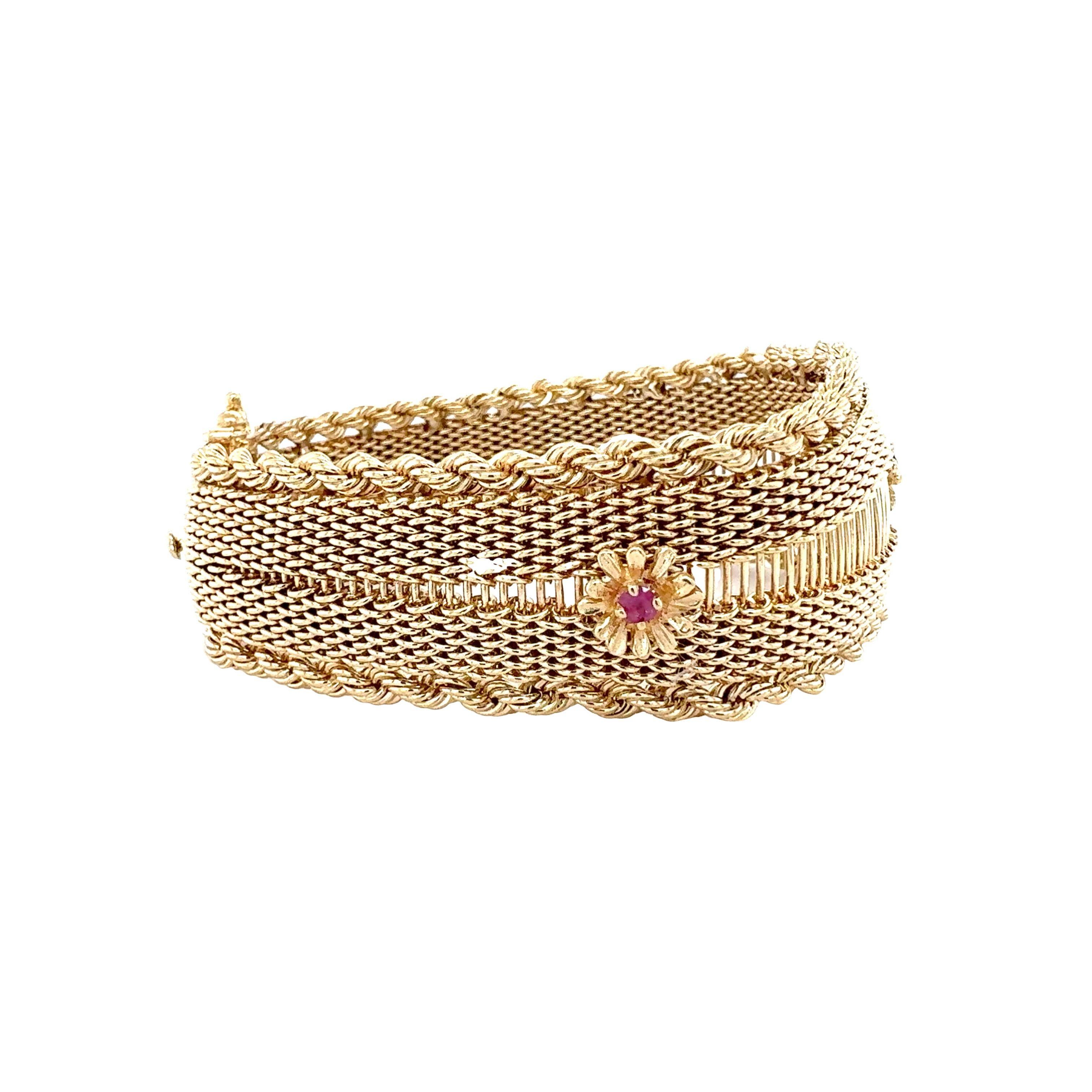 One 14K yellow gold garnet bracelet featuring mesh link design with rope twist gold border and centering three rhodolite garnets weighing 0.24 ct. in total. Measures 26 millimeters wide at center tapering to 17 millimeters at clasp.

Metal: 14K