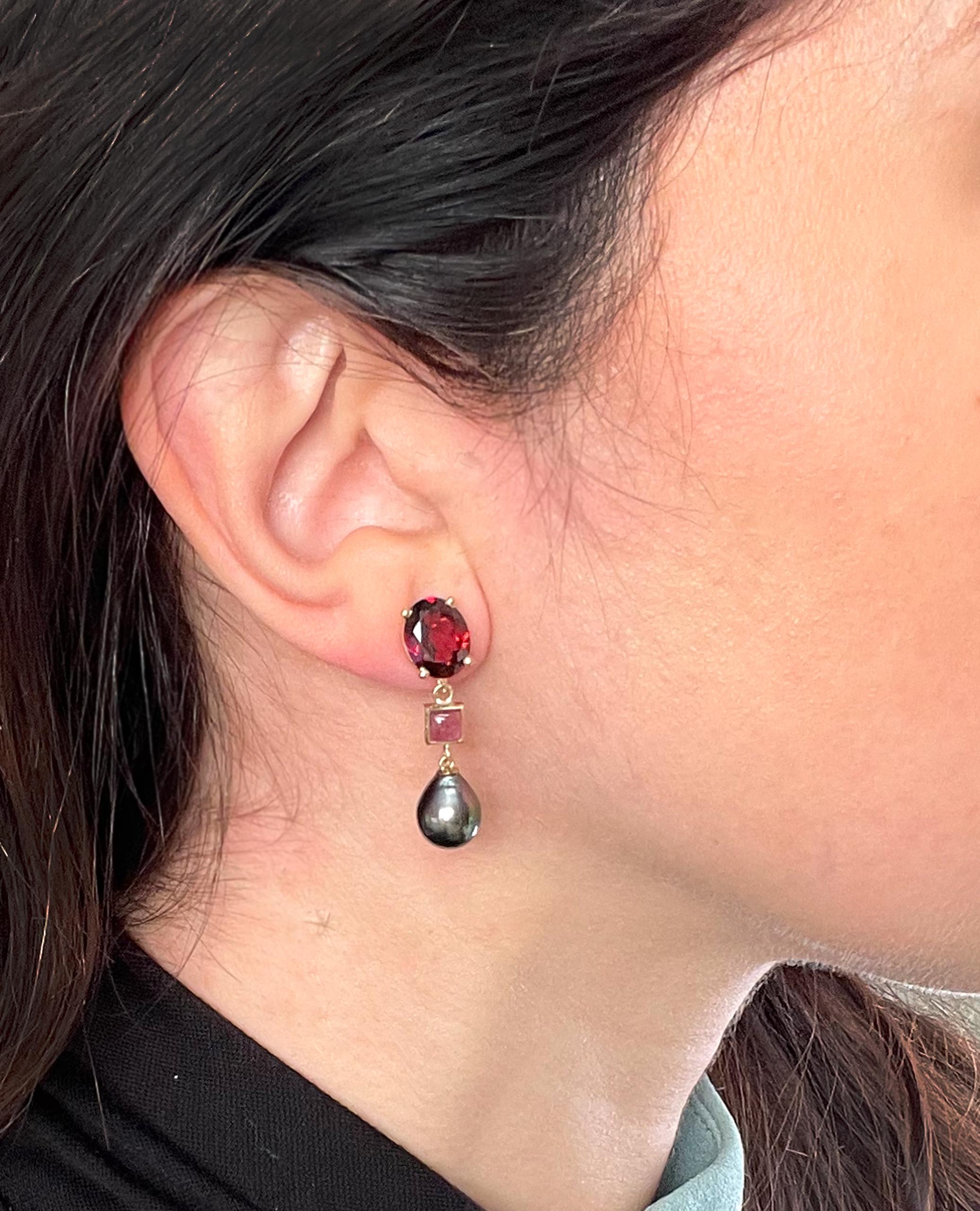 14K yellow gold dangling earrings with two faceted oval garnets weighing 5.02 carats total, two square cabochon pink tourmalines 0.85 carats total  and two baroque black pearls measuring approximately 8.5mm each.