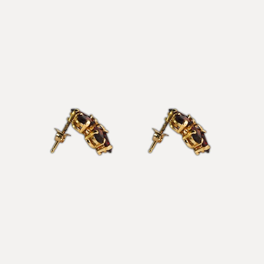 These beautiful, cluster-style 14-karat yellow gold earrings weigh 3.50 grams.
They contain twelve 6x4mm pear-shaped garnet gemstones mounted in a prong setting, with a total carat weight 7.0.
The earrings measure 0.5 inches in diameter and are in