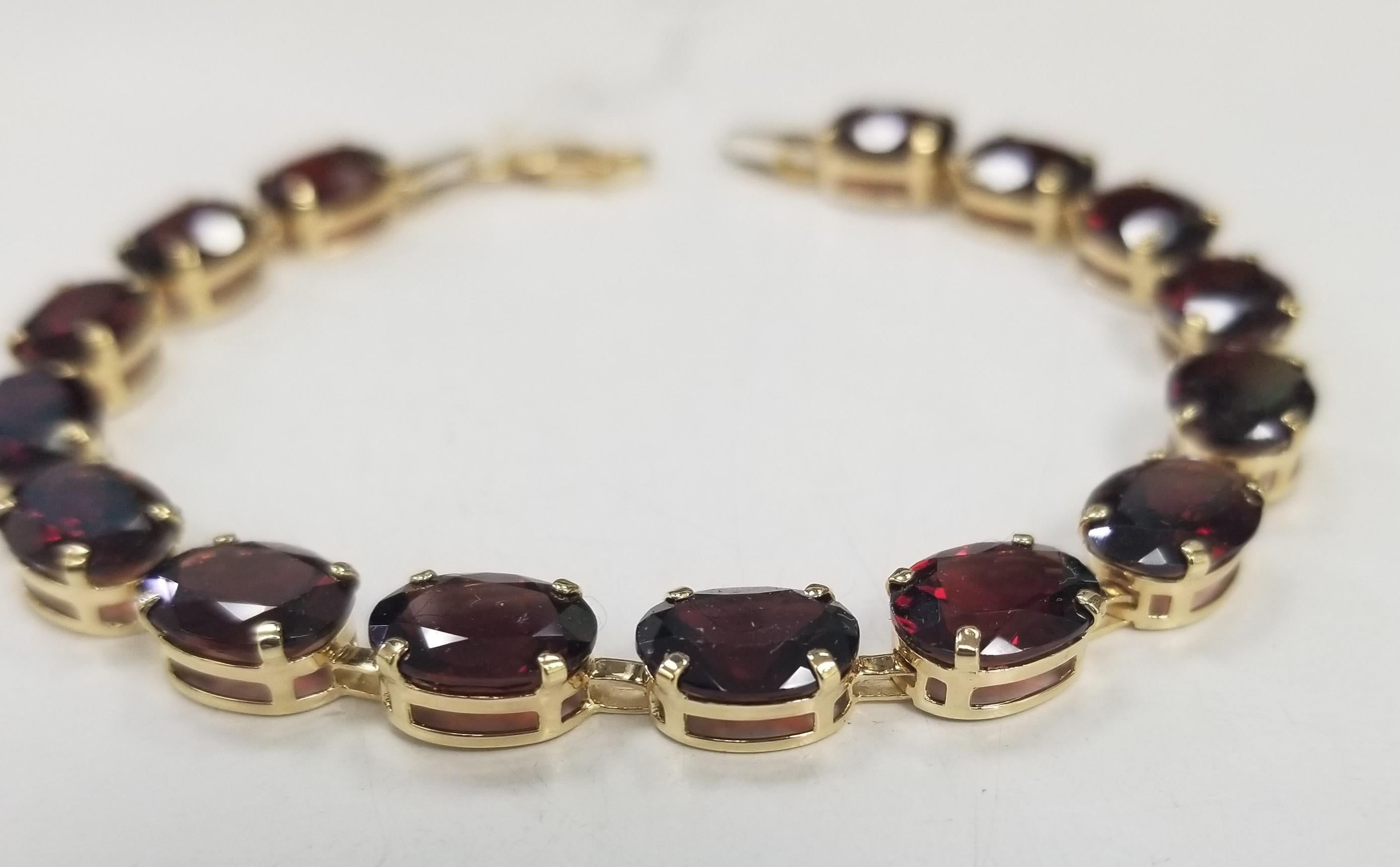 14k yellow gold Garnet prong bracelet, containing 15 oval cut Garnet of gem quality weighing approx. 30.00cts. measuring 7+ inches with lobster claw. Weighing 10.5 grams.
