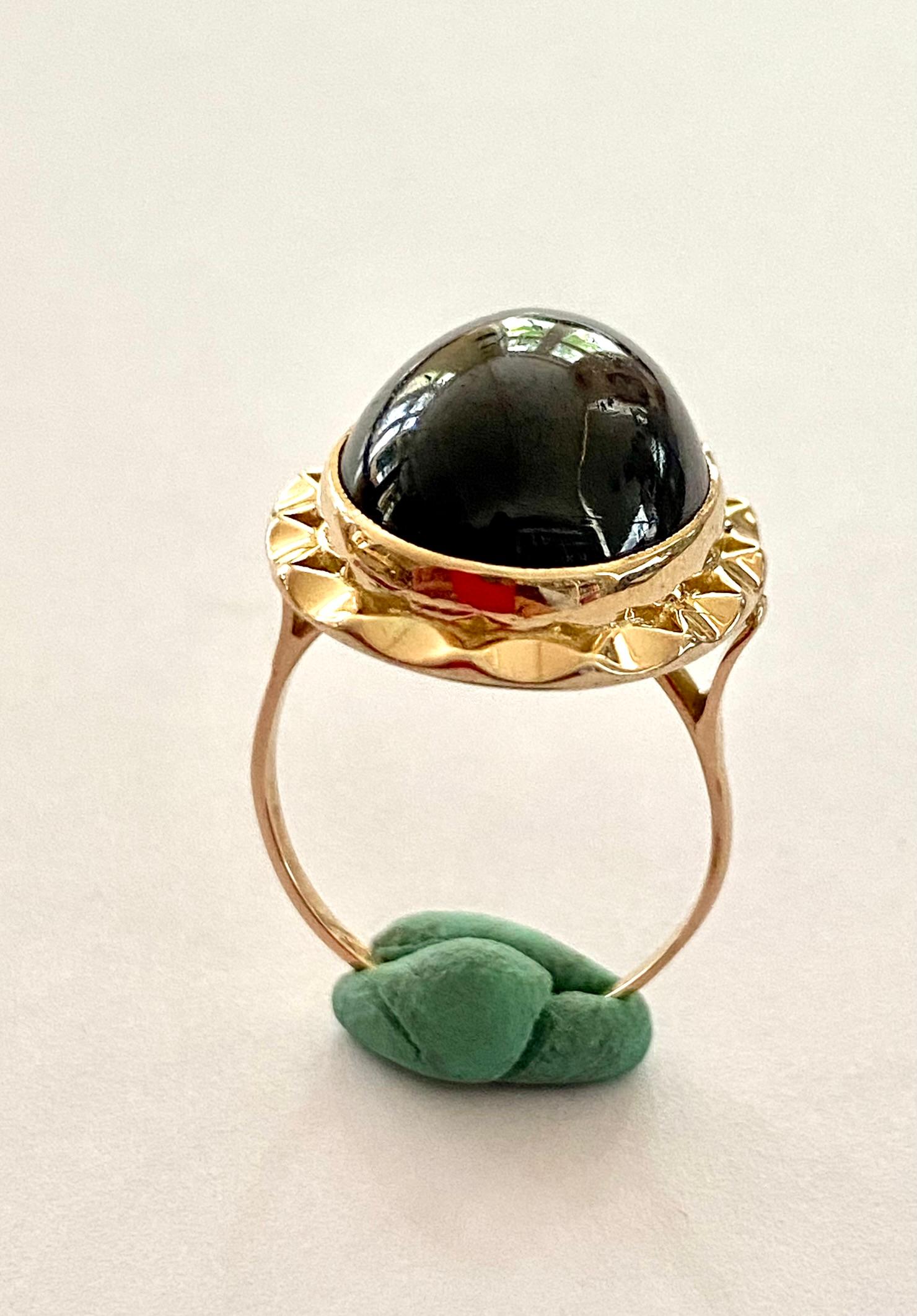 A 14K. yellow gold ring with an oval cut cabochon stone: Garnet.  (RHODOLITE)
Made in the Netherlands around 1960 (vintage)
size garnet: 17 x 12 mm (0.8 x 0.5 inch) the stone looks neat, but with the loupe you can see some signs of wear.
Rhodolit: