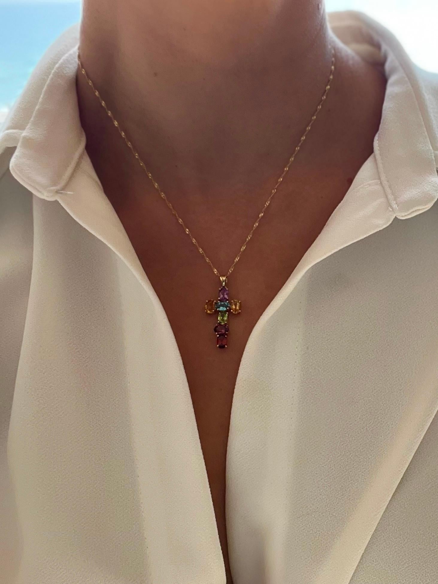 A 14k yellow gold cross necklace composed of our dream natural stones...amethyst, citrine, blue topaz, peridot, rhodolite garnet, and garnet. Stunning pendant in excellent condition paired with a solid 14k yellow gold singapore chain.

One of One -