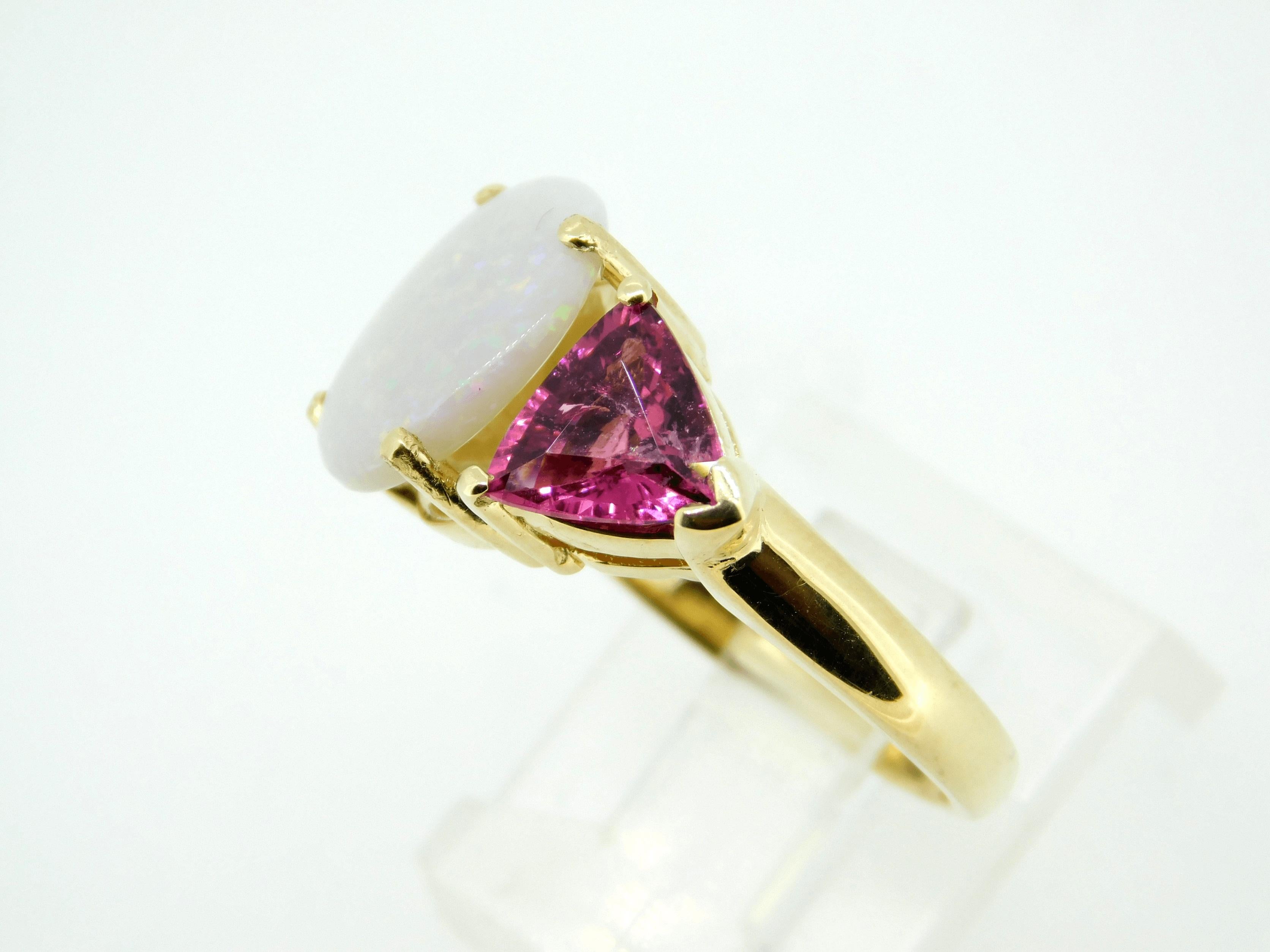 14k Yellow Gold Genuine Natural Opal and Pink Tourmaline Ring (#J4417)

14K yellow gold large three stone ring featuring a large opal and a pair of pink tourmaline trillions. The oval opal weighs 3.75 carats and measures 12x10mm. It has pink pin