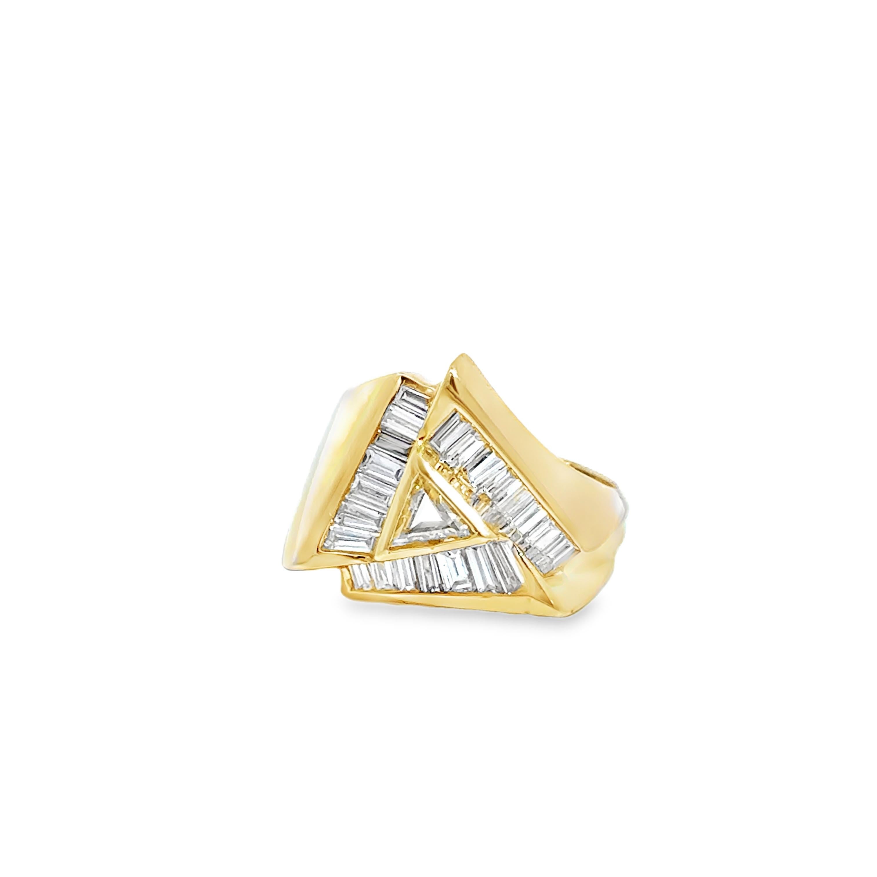 Chef-d'œuvre géométrique en or jaune 14 carats, cette bague sculpturale présente un motif triangulaire audacieux rehaussé par un ensemble étincelant de 24 diamants taille baguette totalisant environ 1,50 carat, encadrant un diamant trillion de 0,33