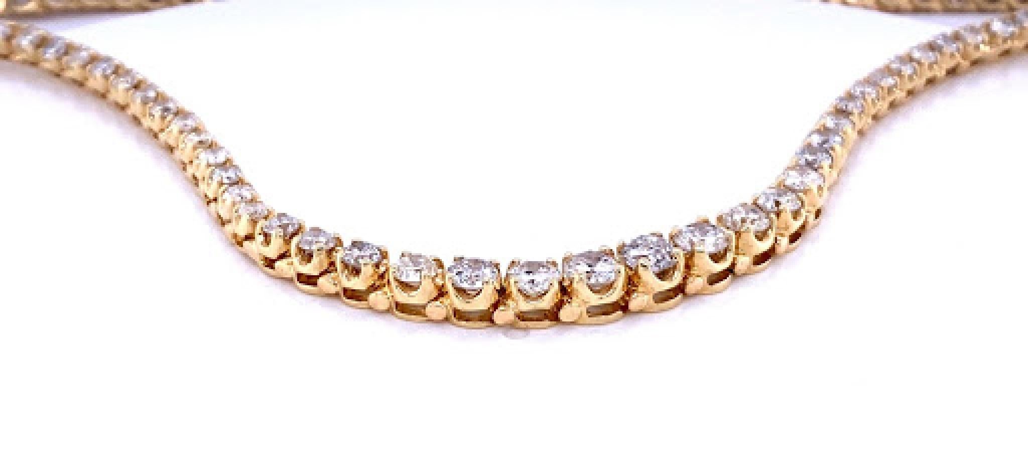 14 karat yellow gold (stamped 14k) graduated diamond tennis necklace. Diamonds decreasing from 4.3 mm to 2.3 mm as they get closer to the clasp. Diamonds are a H/I color, SI, and weigh approximately 9.50 total carats. The necklace measures 16.25