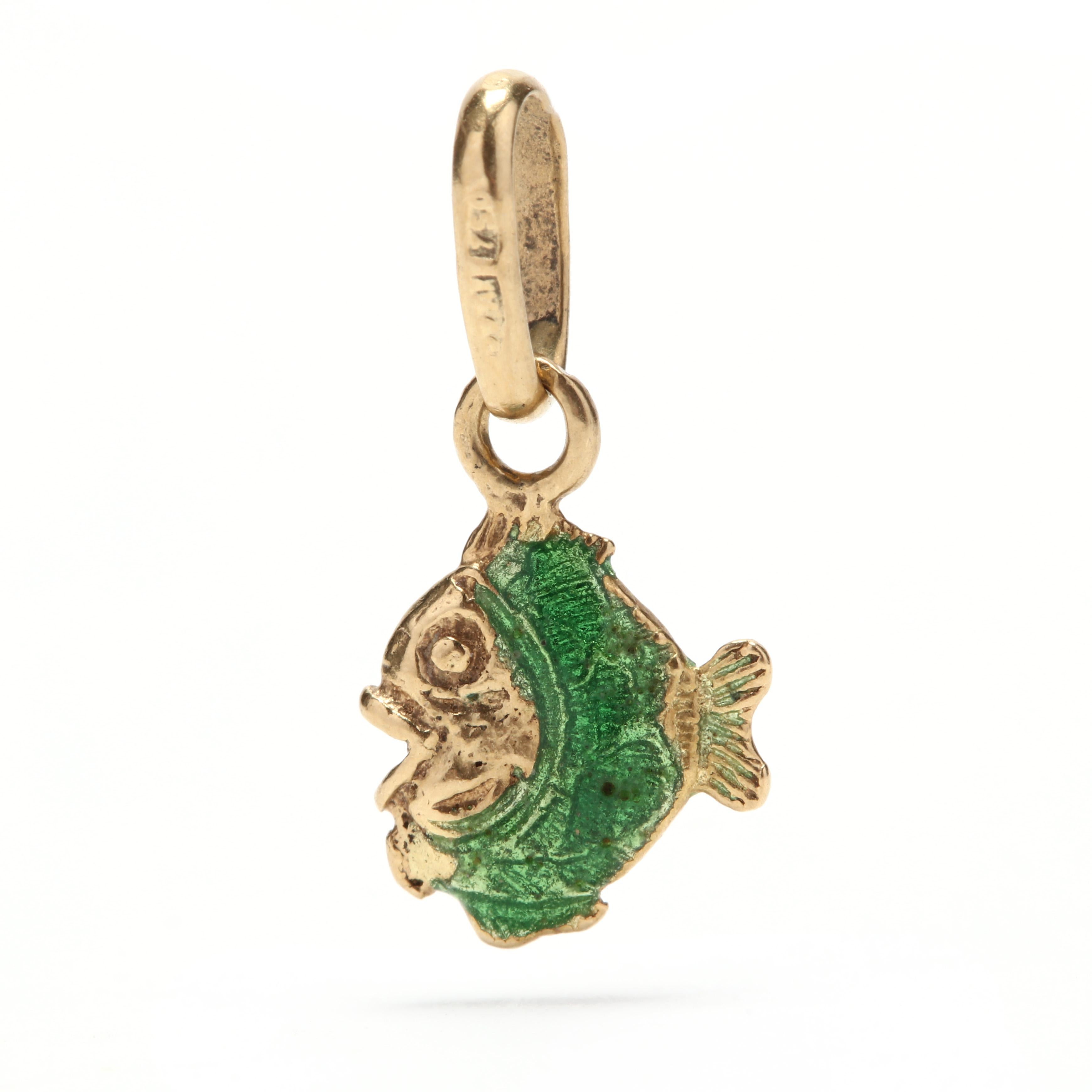 A 14 karat yellow gold and green enamel fish charm / pendant. This pendant features an open mouthed fish motif with engraved detailing covered in translucent green enamel.

Length: 11/16 in.

Width: 5/16 in.

.63 dwts.
* Please note that this is a