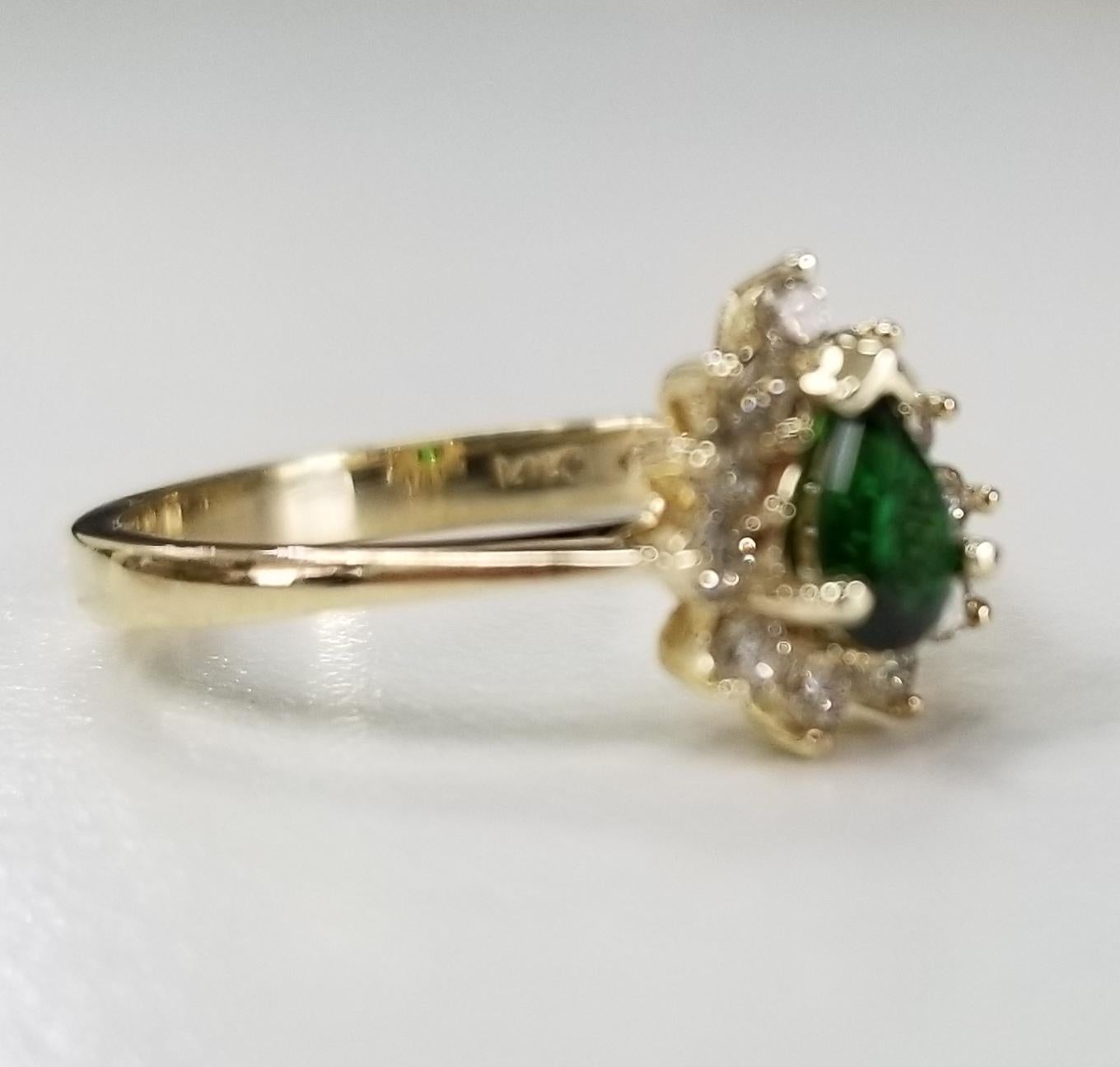 14k yellow gold Green Tourmaline and diamond ring, containing 1 pear shape cut tourmaline weighing .33pts. and 11 round full cut diamonds of very fine quality weighing .25pts.  This ring is a size 5 but we will size to fit for free.