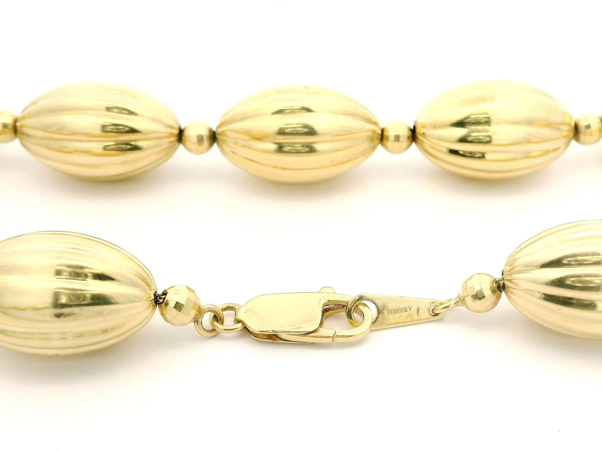 Matériau : Or jaune 14K
Poids : 33,64 grammes
Type de collier : Baril cannelé et perles à facettes sur chaîne à maillons en câble
Longueur du collier : 18 pouces
Fermeture : Fermeture à griffe de homard
Epaisseur des perles : 3.7mm (rond)-  11,3 mm
