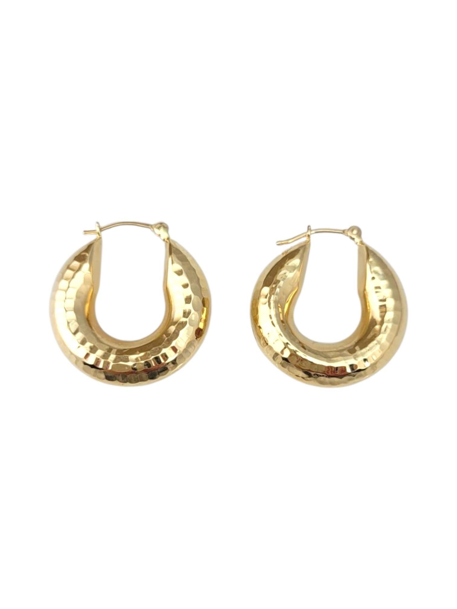 14K Yellow Gold Hammered Hoop Earrings 

These hammered hoop earrings feature a textured finish that catches the light beautifully, adding depth and dimension to a classic silhouette. Their artisanal look offers a modern twist on timeless