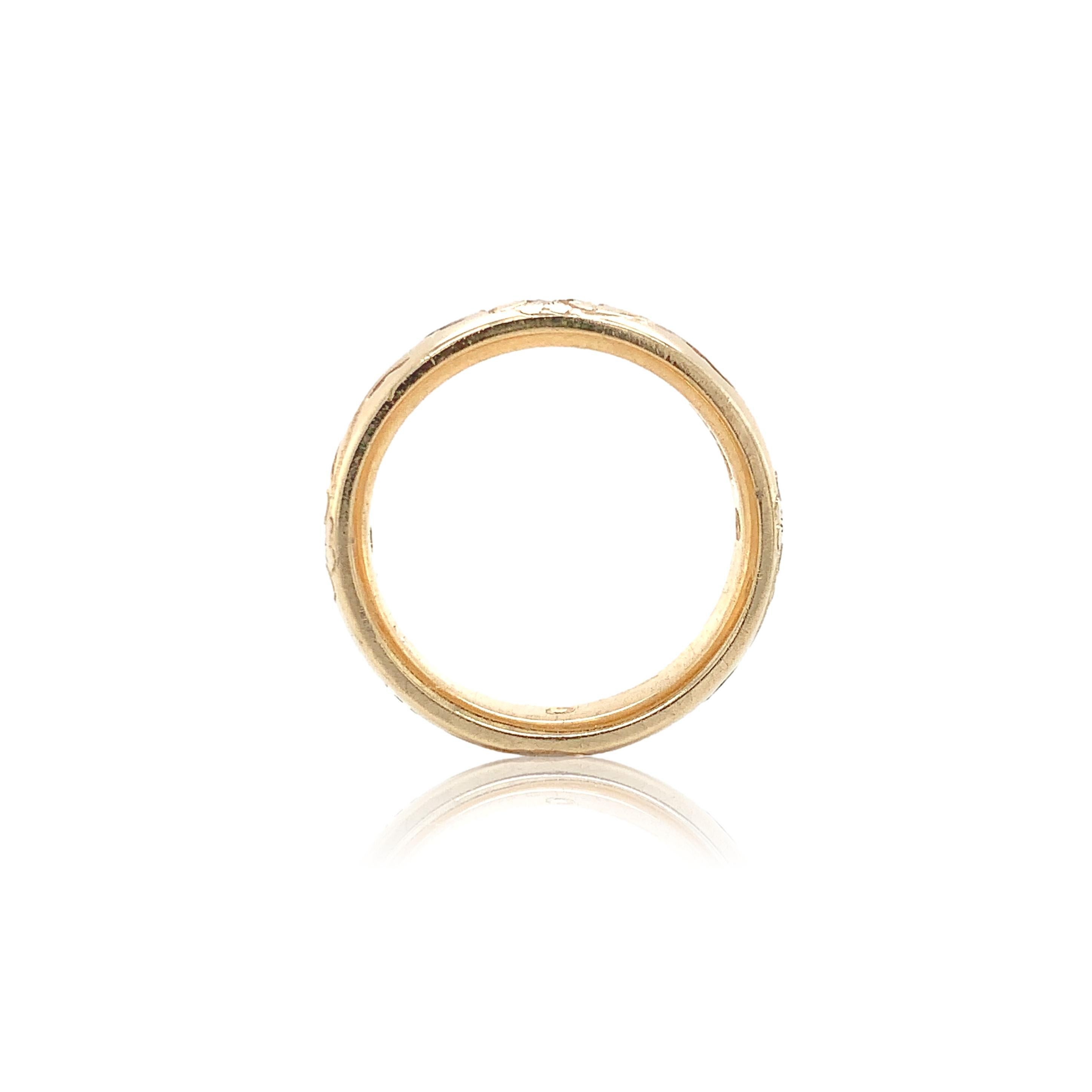 14K yellow gold wide comfort fit wedding band ring set with diamonds and engraved with a floral vine design.  The ring  measures 4.9mm wide and is set with 4 round brilliant cut diamonds measuring 2mm and weighing .15cts total. The band fits a size