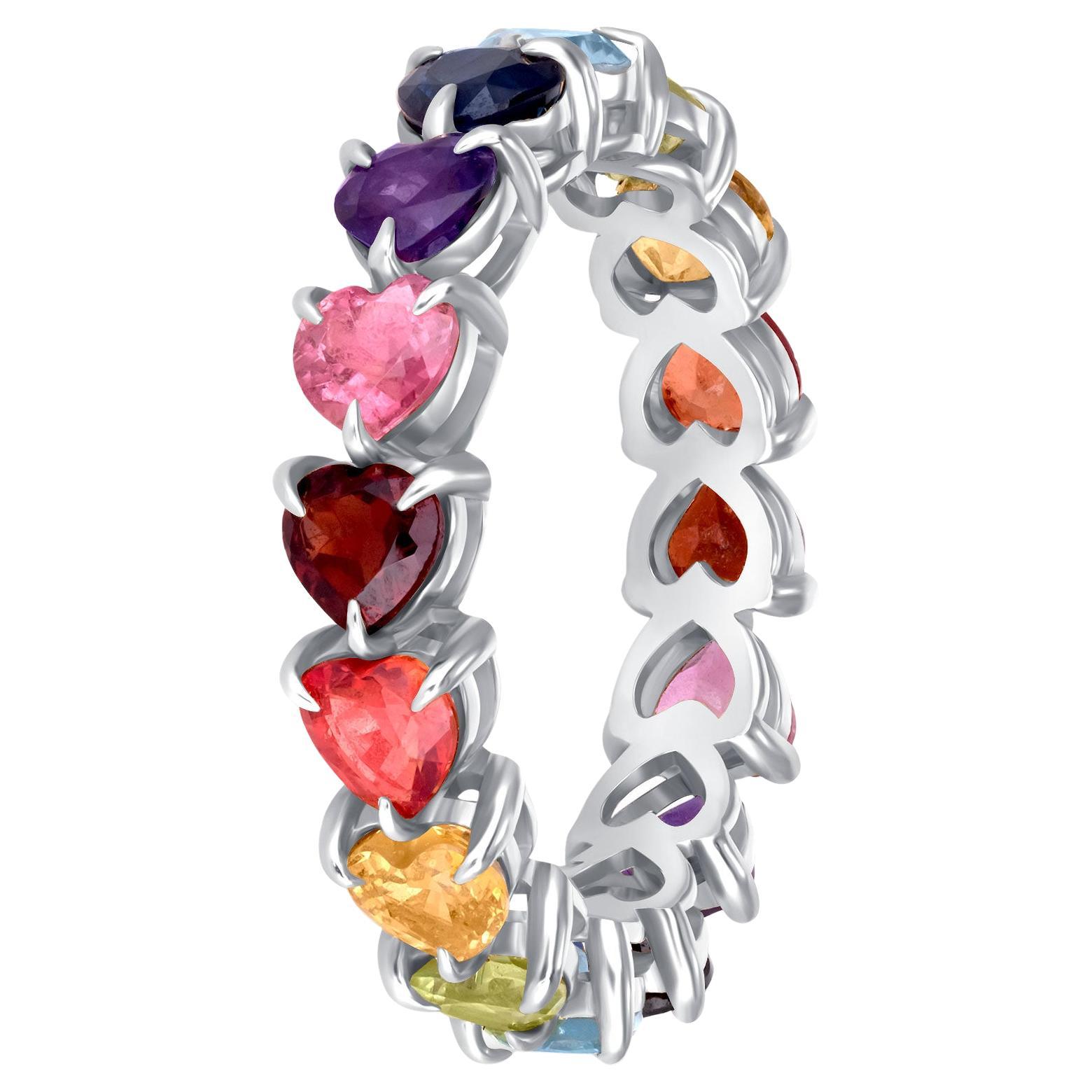 Celebrate vibrant expression and elegant craftsmanship with this 14K Yellow Gold Rainbow Eternity Ring. Handcrafted in the USA, this statement ring features 16 vibrant heart-cut gemstones including sapphires, garnet, and topaz, each ethically